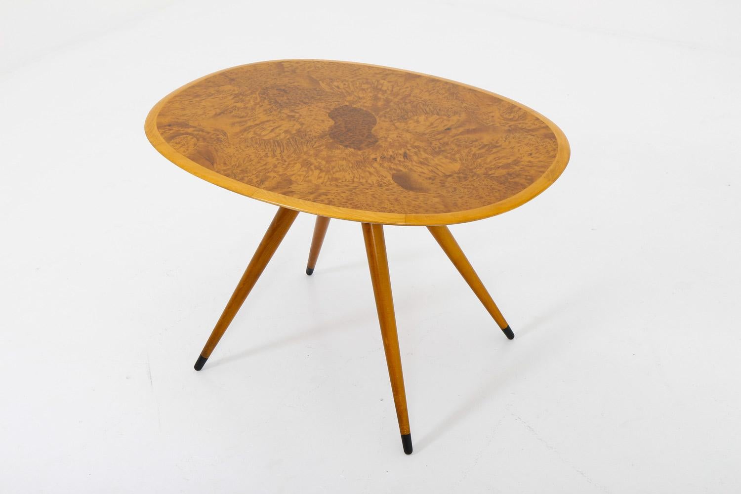 This coffee table, attributed to the renowned designer David Rosén, exudes elegance and sophistication with its beautiful elm root inlay on the top and distinct angled legs. Despite a few scratches and signs of use on the table top, it remains in