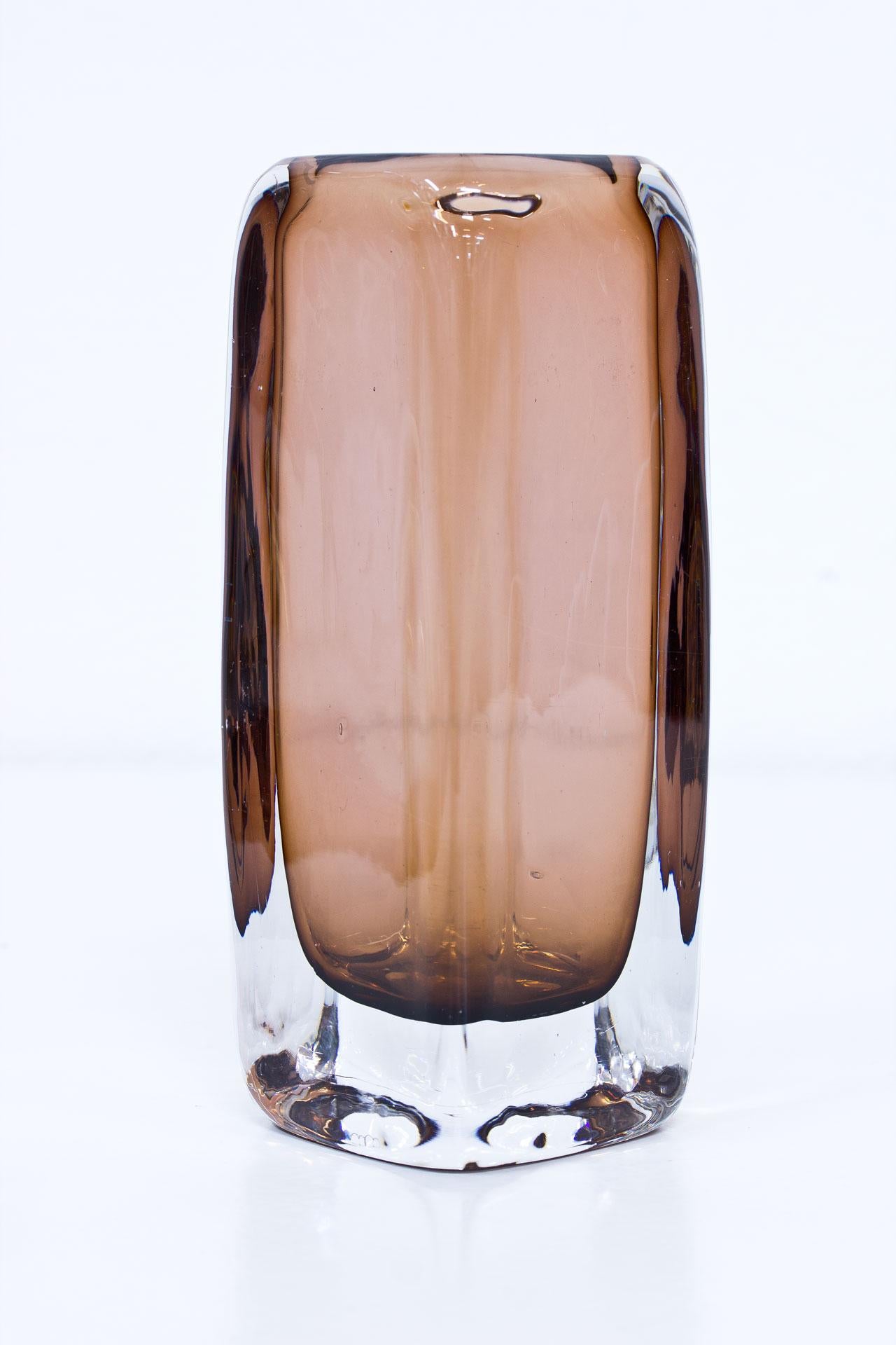 Thick and heavy crystal glass vase designed by Vicke Lindstrand. Manufactured at Kosta glass factory in Sweden during the 1950s. Colored glass cased in clear glass technique. Engraved on bottom.
