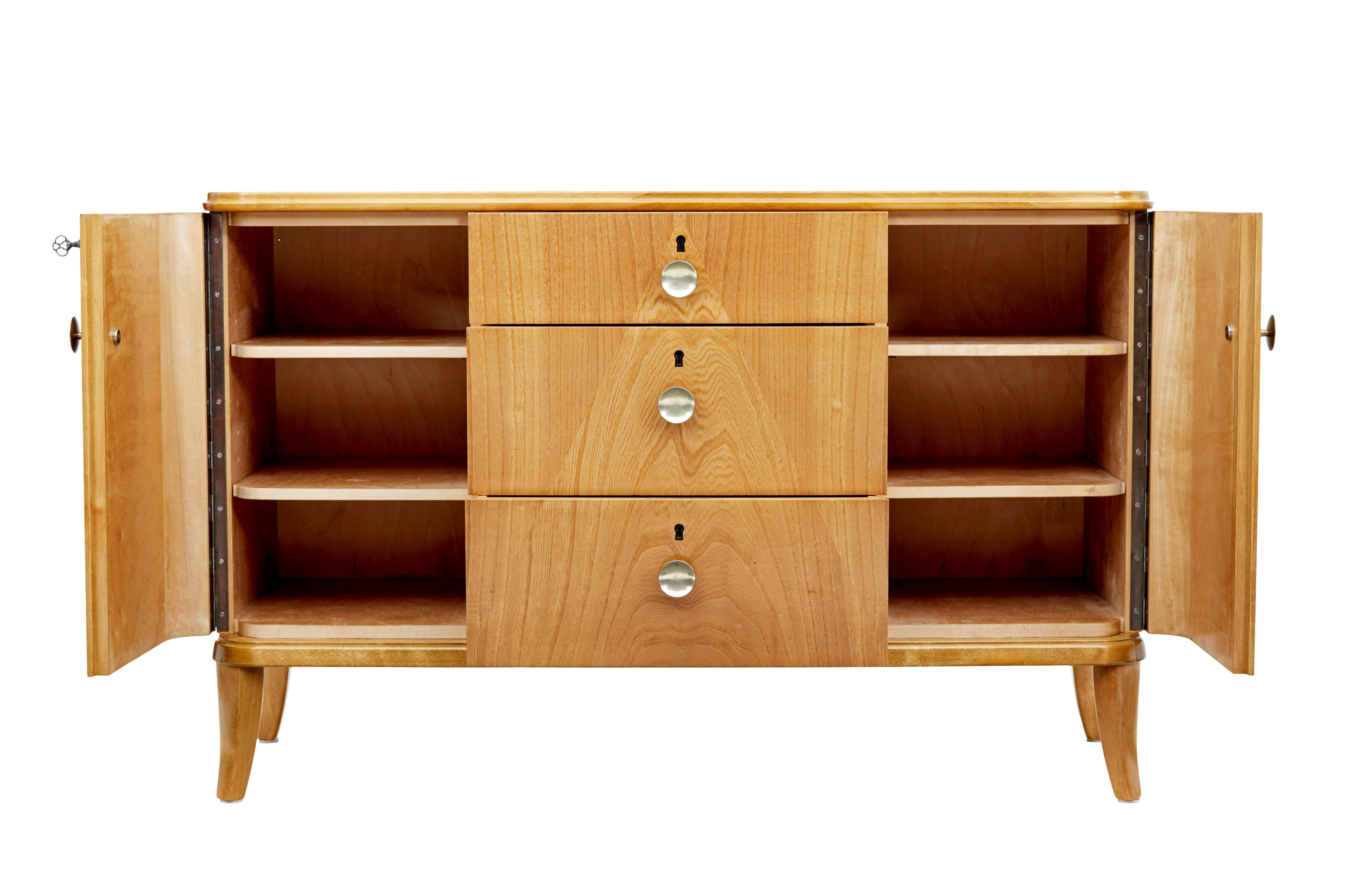Mid century Swedish elm chest of drawers circa 1960.

Fine quality Swedish chest which offers the best of both worlds with drawers and cupboard space.  Chest fitted with 3 central graduating drawers, with an arranged pattern in the veneer.  Flanked