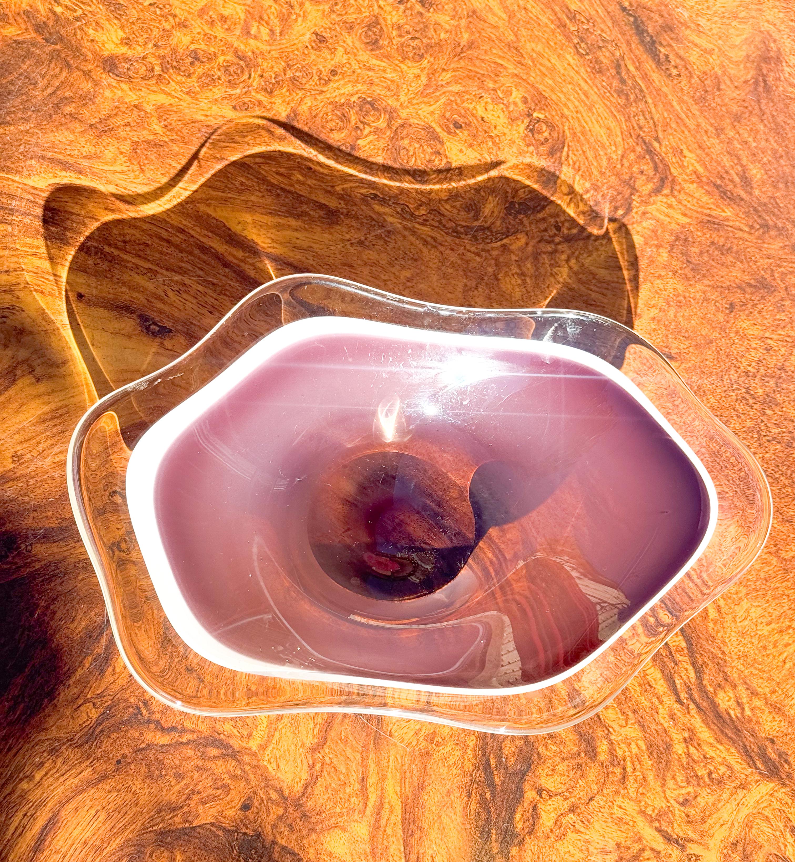 This striking handblown art glass bowl is attributed to the Coquille series designed by Paul Kedelv for Flygsfors Glasbruk, Sweden, in the late 1950s. Crafted with the signature Coquille technique, the piece features a flowing, organic rim paired
