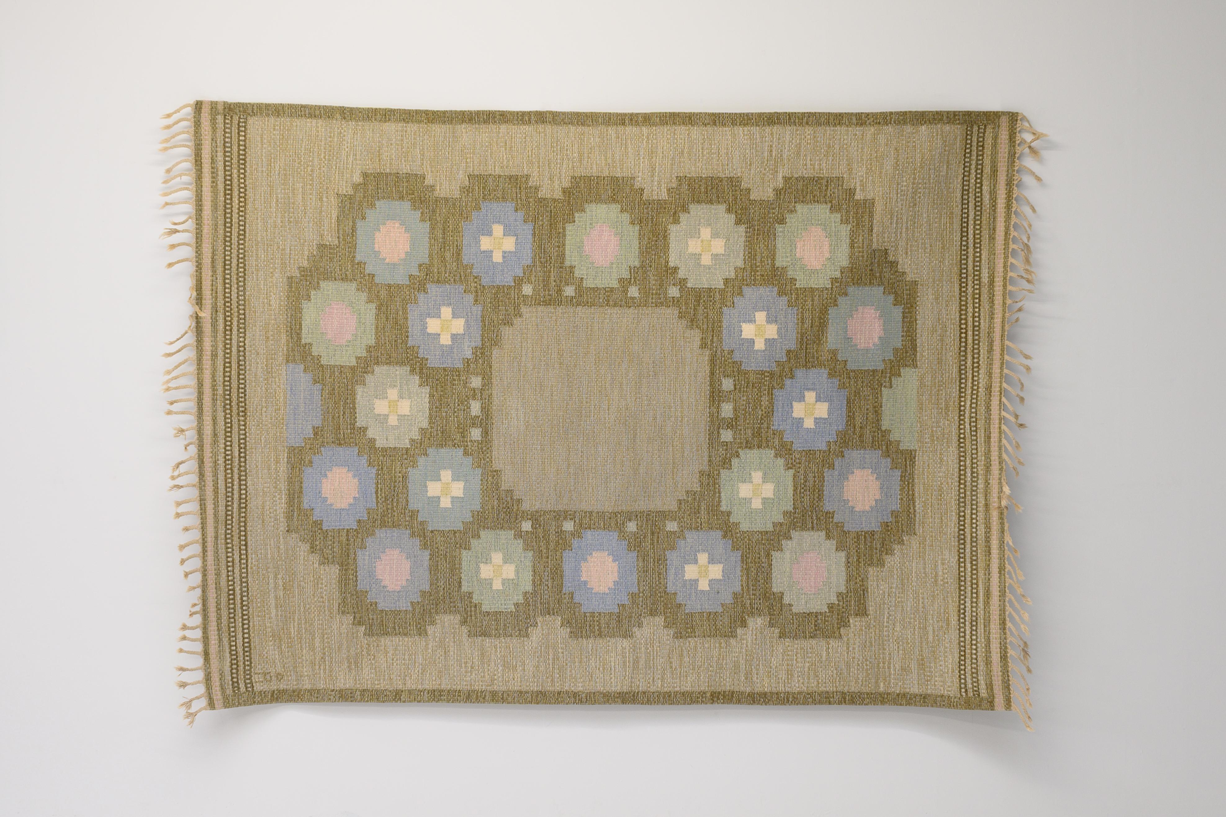 Large size mid-century Swedish kilim in tones of pale green and browns with an unusual medallion design around a square centre. Signed Anna Johanna Angstrom. Professionally cleaned.