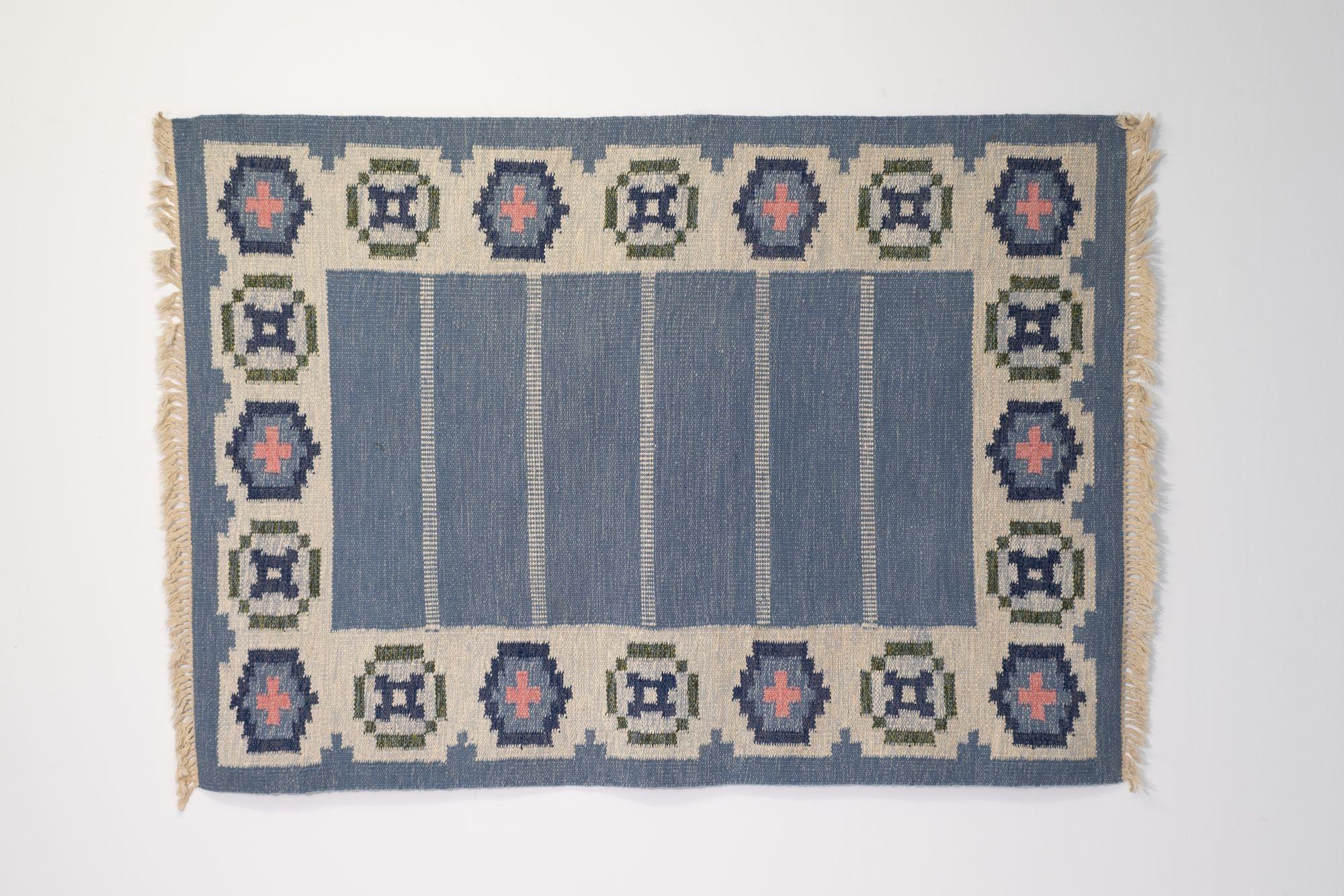 Mid-Century Swedish kilim in the manner of Ingergerd Silow. In tones of blue and cream, with a scalloped border.
Sweden circa 1960.
H 1cm x W 144cm x D 199cm