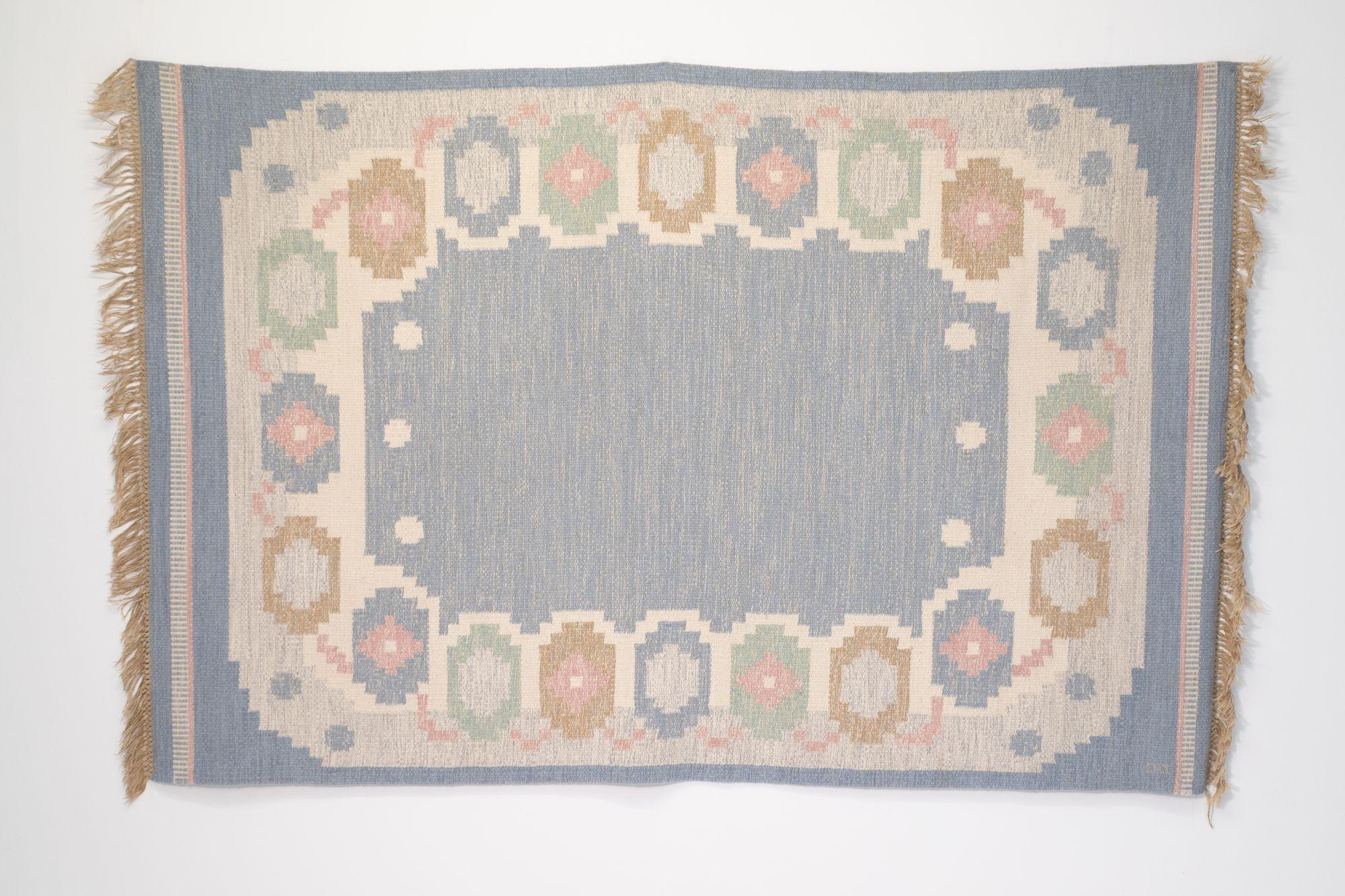 Large size mid-century Swedish kilim on tones of blues and creams with touches of pink and green. By Anna Johanna Angstrom.
Circa 1960.
H 1cm x W 166cm x D 250cm