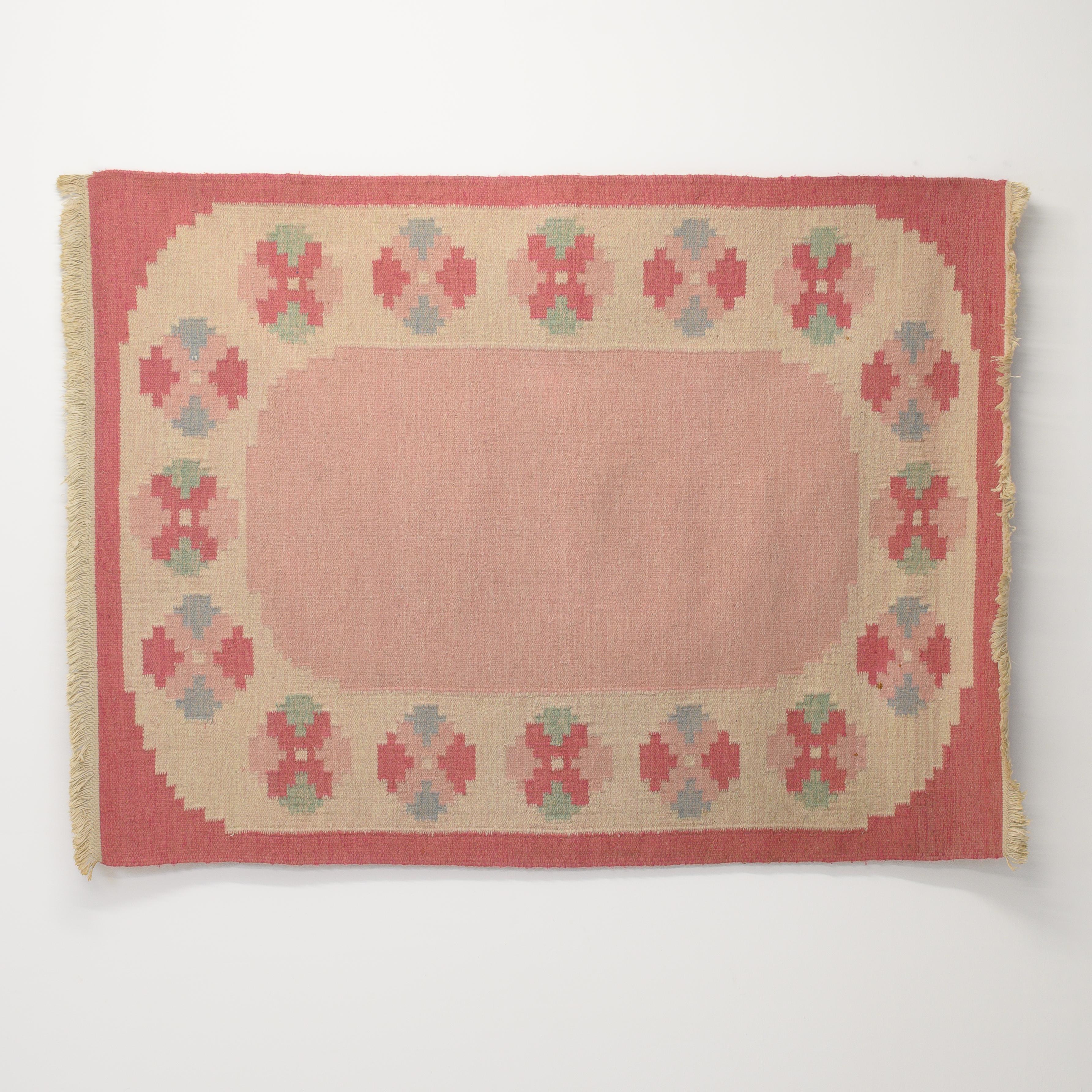 Mid-Century Swedish kilim in tones of pink and cream with a central plain area circled with medallions. Professionally cleaned.