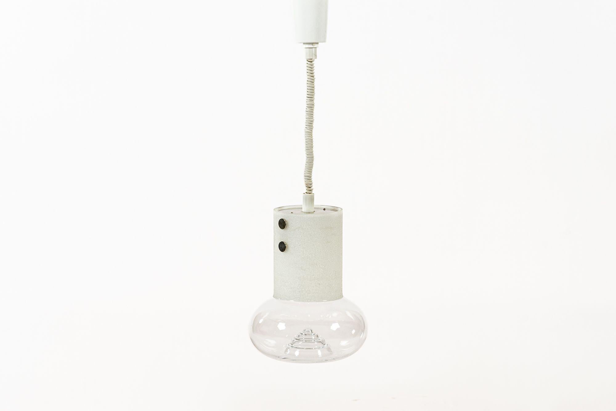 This vintage mid century Scandinavian modern glass hanging pendant light designed by Olle Alberius and manufactured by Orrefors was made in Sweden circa 1960. This premium quality lamp is heavy and well-crafted with a white textured ice chip glass