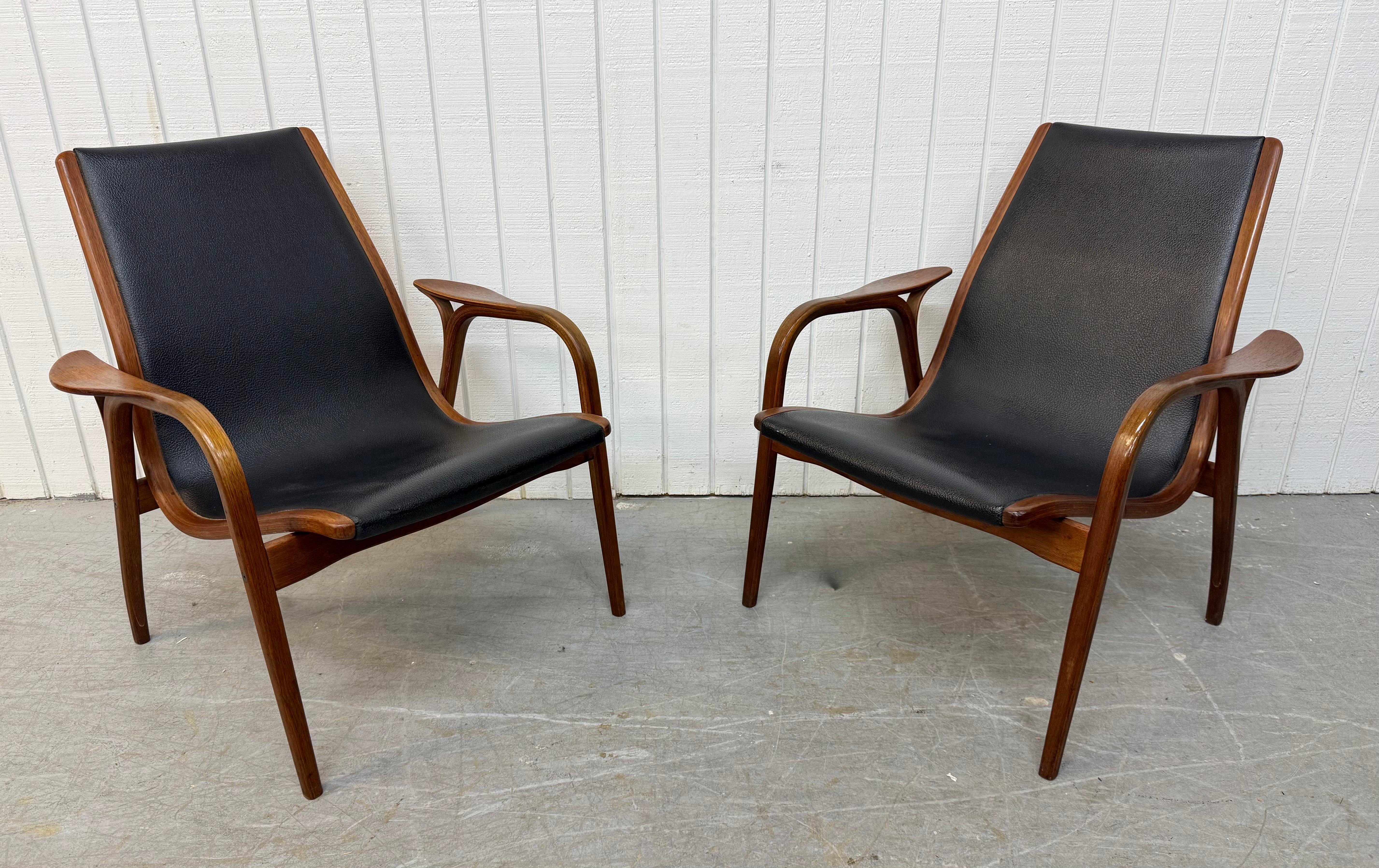 This listing is for a pair of Mid-Century Swedish Modern Lamino Walnut Lounge Chairs. Featuring a curved bent wood design, black leather upholstery, and a beautiful walnut finish. This is an exceptional combination of quality and Swedish MCM design