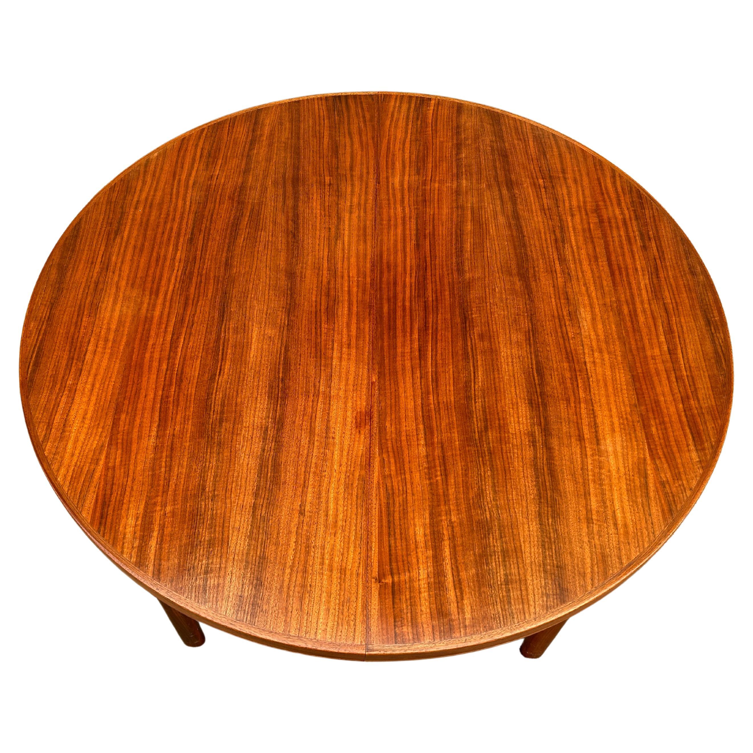 Midcentury Swedish Modern Round dining table. This table is very high quality hand built in Sweden. Solid teak legs with 4 leg base. This table is in great vintage condition, the (2) leaves. Beautiful wood grain and edge detail. Beautiful teak