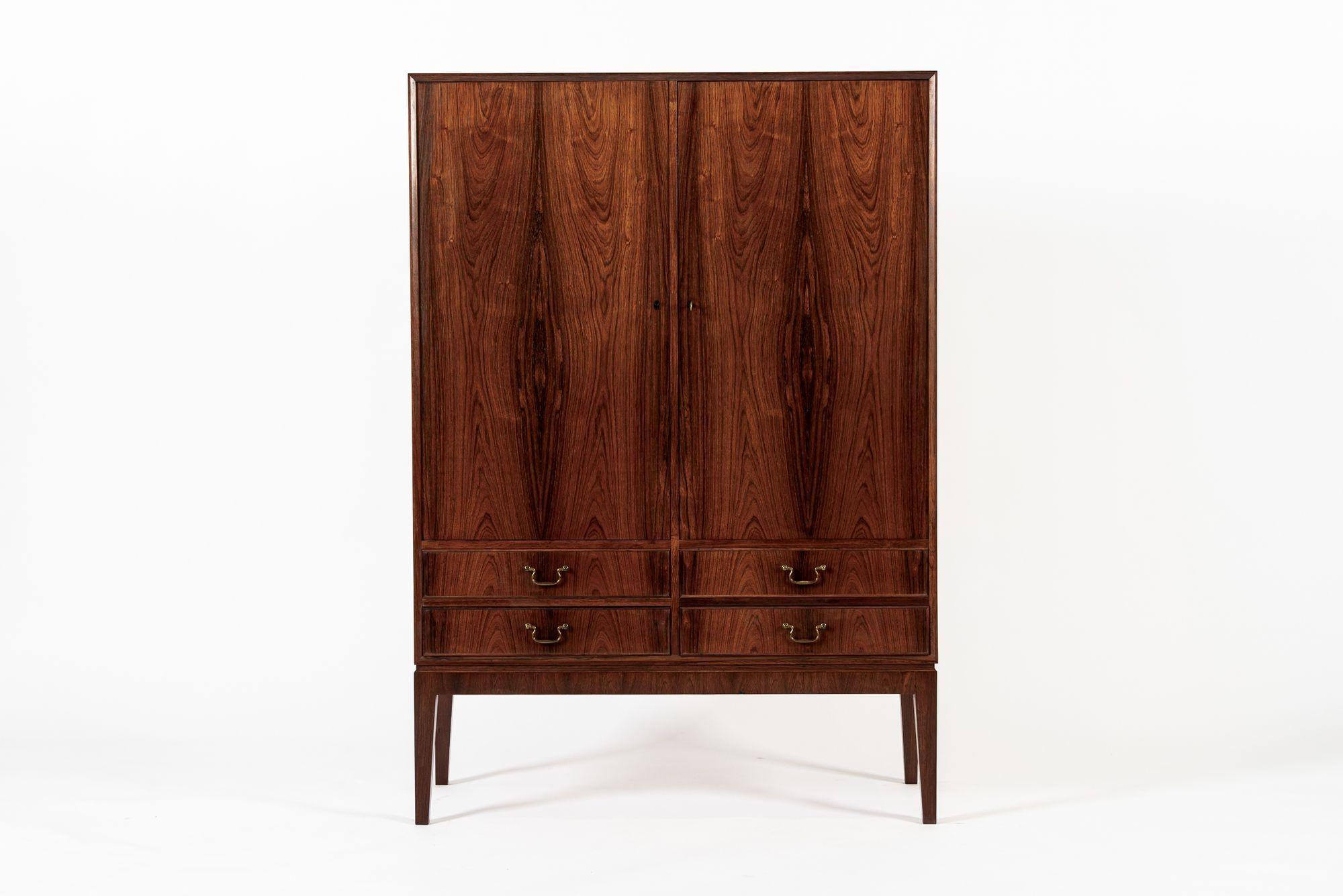 Questo eccezionale mobile danese moderno in legno di palissandro della metà del secolo scorso, realizzato alla maniera di Kaare Klint, risale al 1960 circa. Questo mobile alto in stile ebanista ha proporzioni eleganti, linee pulite e minimaliste ed