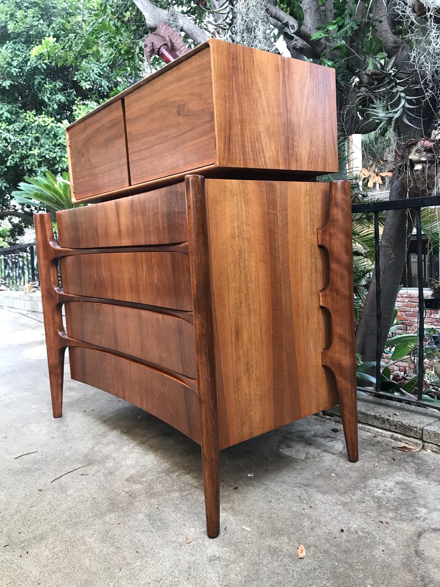 This is a stunning 2 piece Highboy chest of drawers with matching cabinet designed by William Hinn of Sweden circa 1960’s. The dresser consists of a bottom chest of four drawers and a separate smaller cabinet that sits on top. They can be used