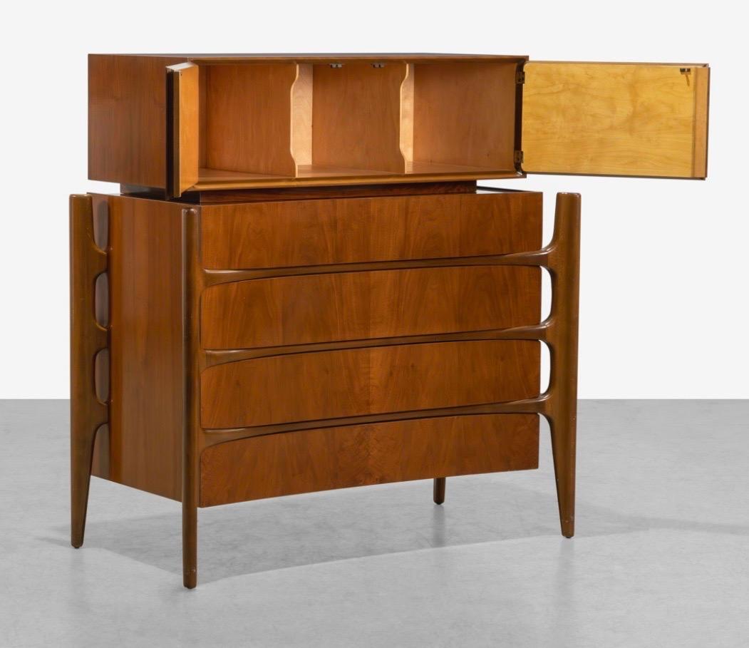 Questo annuncio si riferisce a una cassapanca in legno di noce di William Hinn. Caratterizzato da un design lineare con gambe scolpite, uno scomparto superiore rimovibile che si apre per riporre gli oggetti, quattro cassetti a coda di rondine e una
