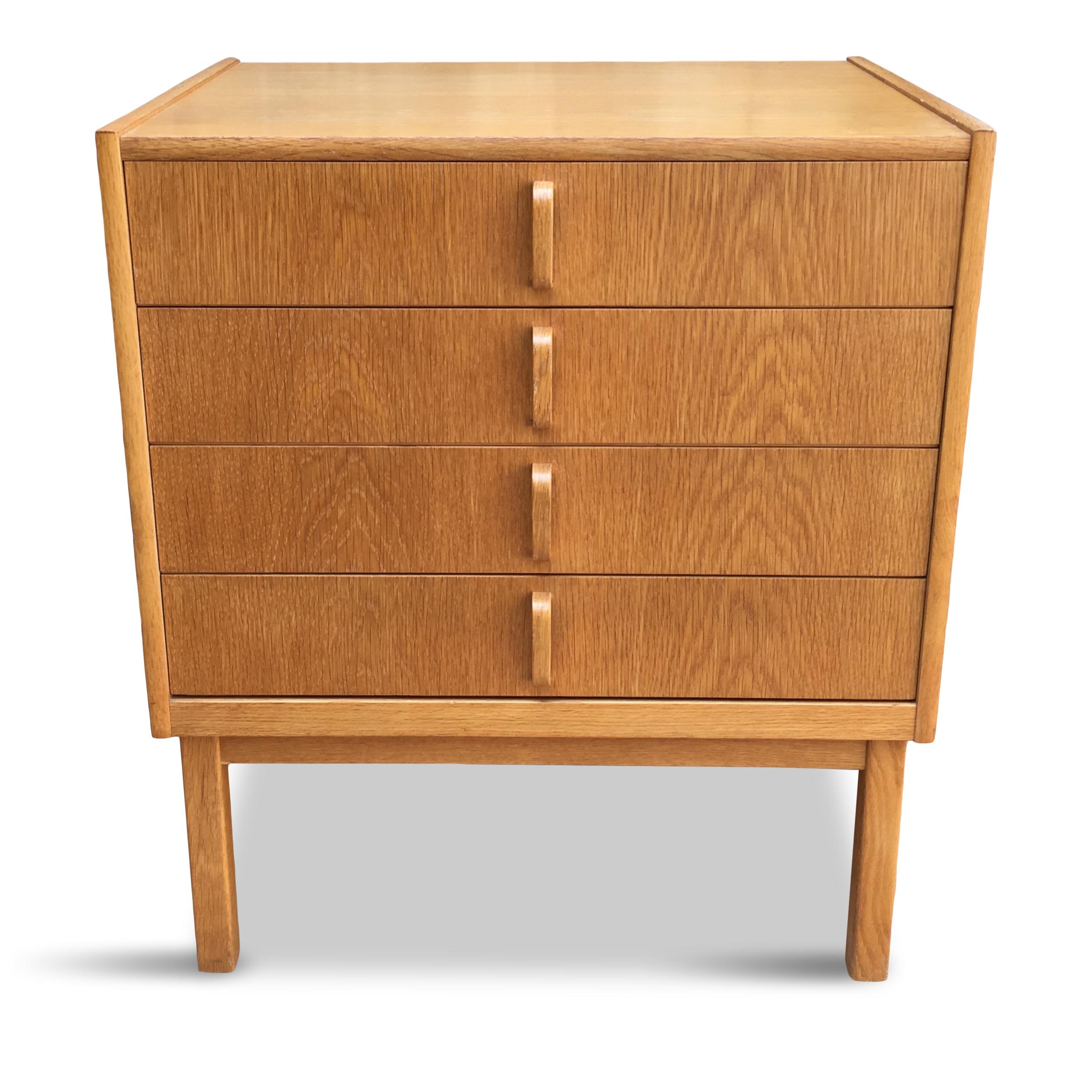 Minimalist form chest of drawers with brass details on the sides. Each drawer features green laminated bottom.