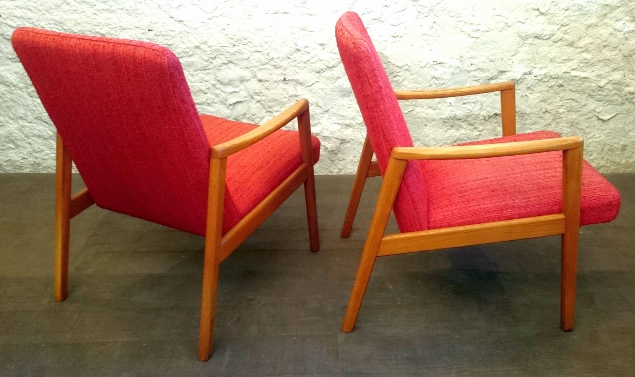 A pair of´Swedish 1950s oak armchairs with original fabric in strawberry red wool. Stabile and good condition. Additional pics can be sent upon request. Excellent pieces for reupholstering in your own fabric.