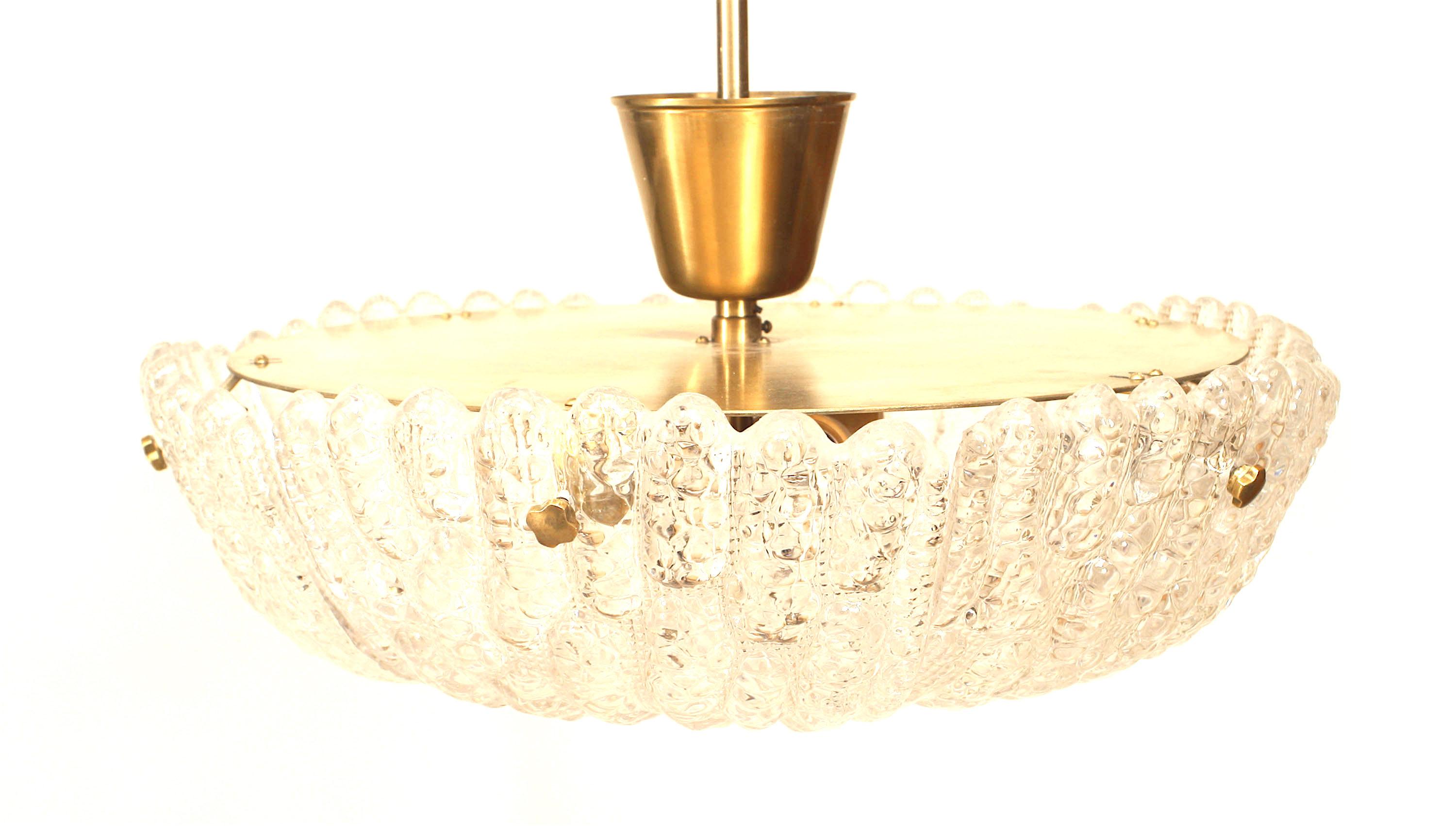 Mid-century Swedish Orrefors chandelier with a round molded glass base with a fluted design and scalloped edge suspended from a simple brass shaft.