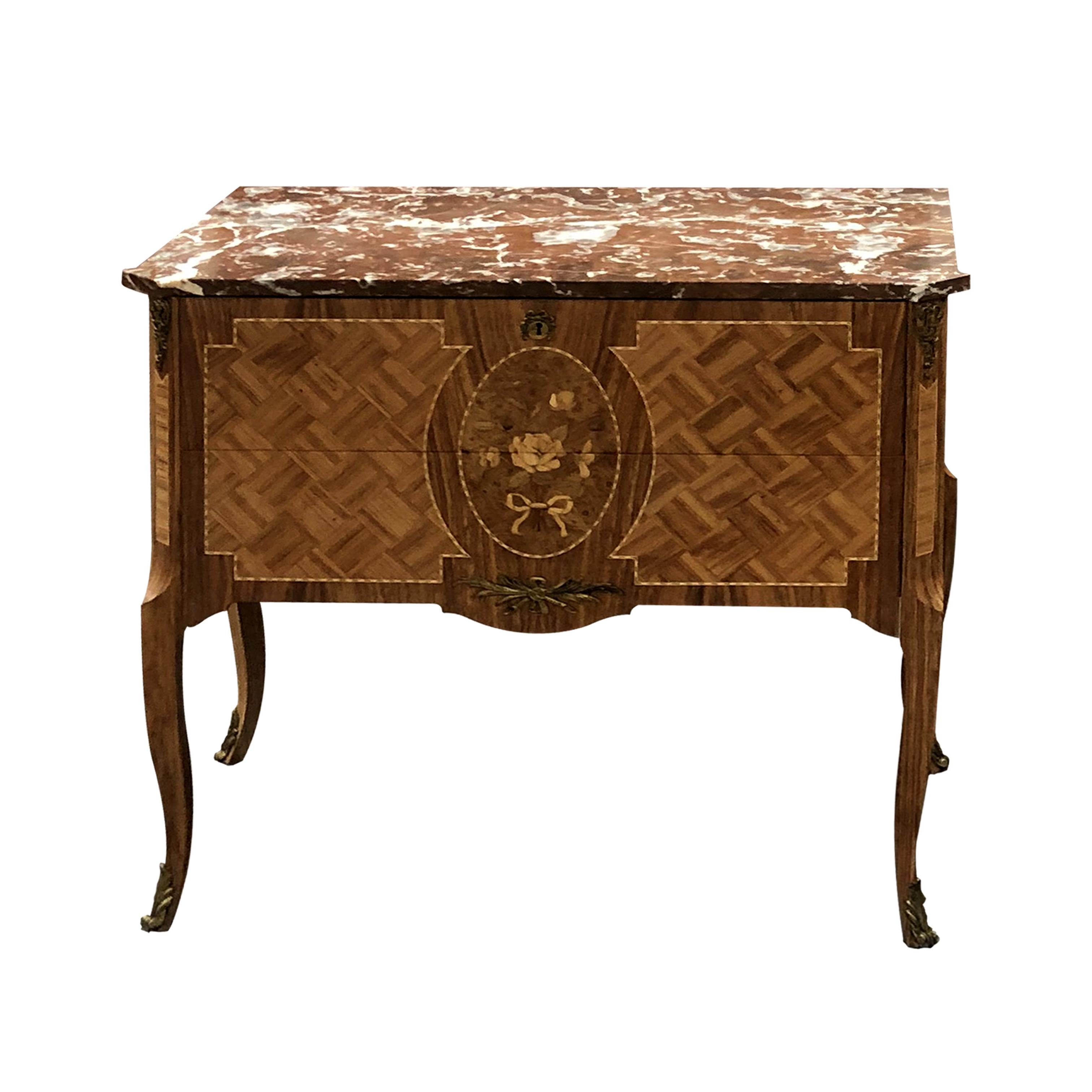 A pair of early 20th century Swedish marquetry chest of drawers or bedside tables with their original marble tops, gilt mounts and escutcheons. The chests of drawers are made of many different woods. One of the chests has a darker marquetry surround