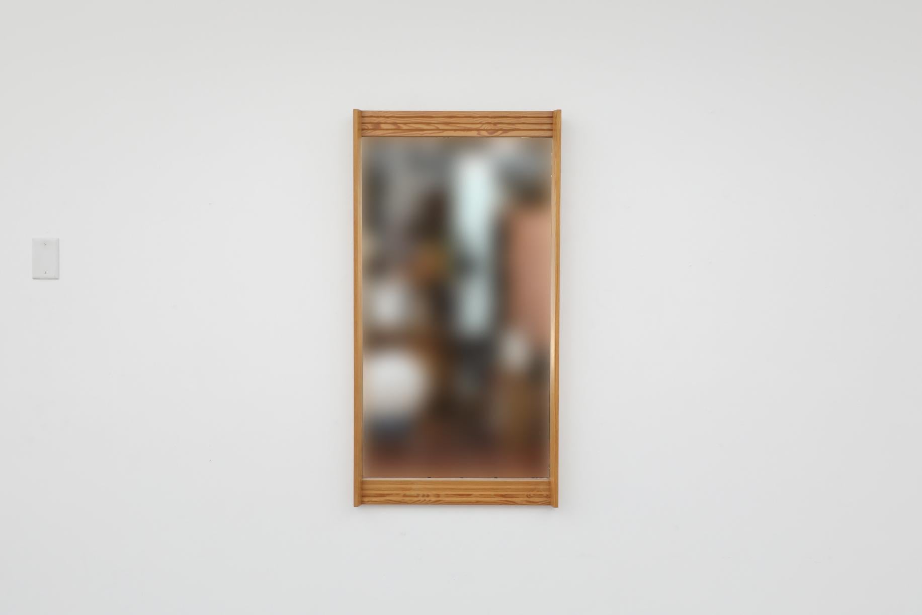 Mid-Century Swedish wall mounted mirror with solid pine, layered-design frame on the top and bottom. In original condition with visible wear consistent with its age and use.

