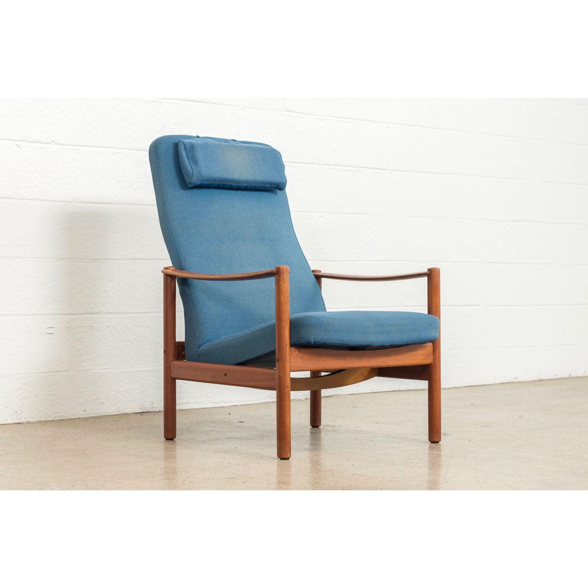 This vintage mid century Swedish modern Folke Ohlsson for DUX style reclining high-back lounge chair is circa 1960. This well-built chair features a minimalist Scandinavian modern design with clean lines and elegant curves. The solid teak wood frame