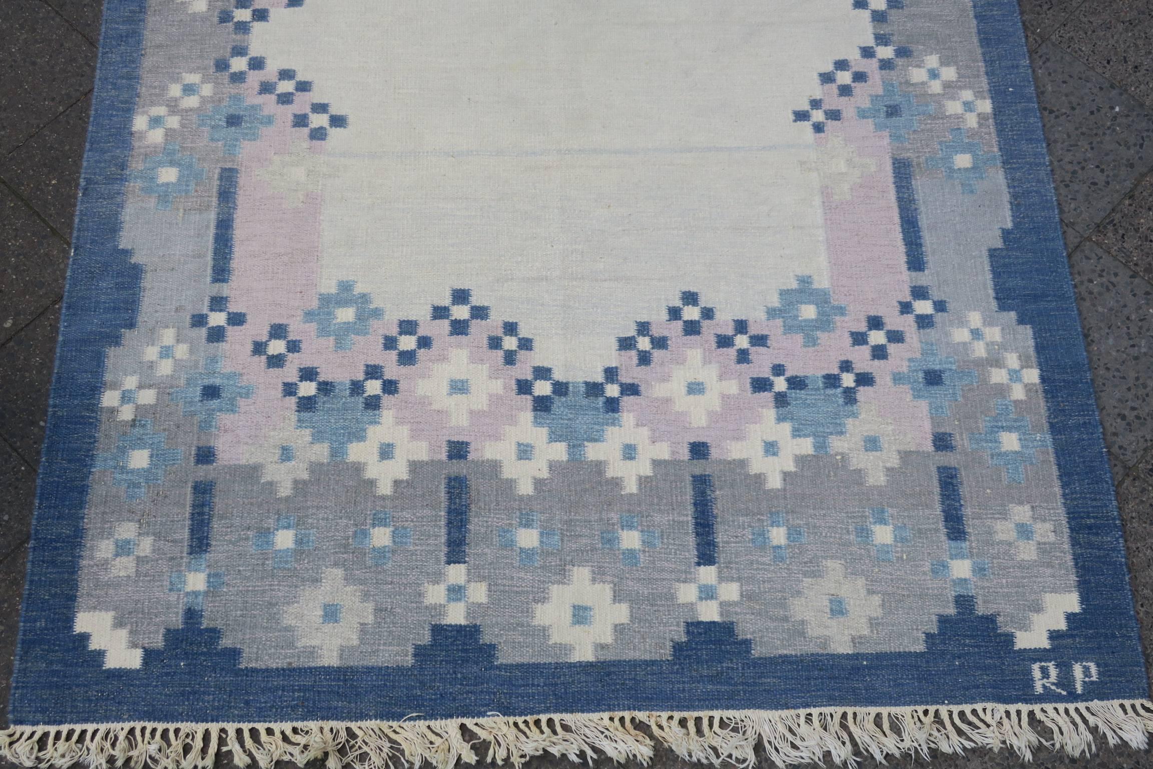Midcentury Scandinavian signed kelim with a geometric design in light colors. Both sides can be used, with slightly different coloring on each side (the last three pictures show the 'back' of the rug).