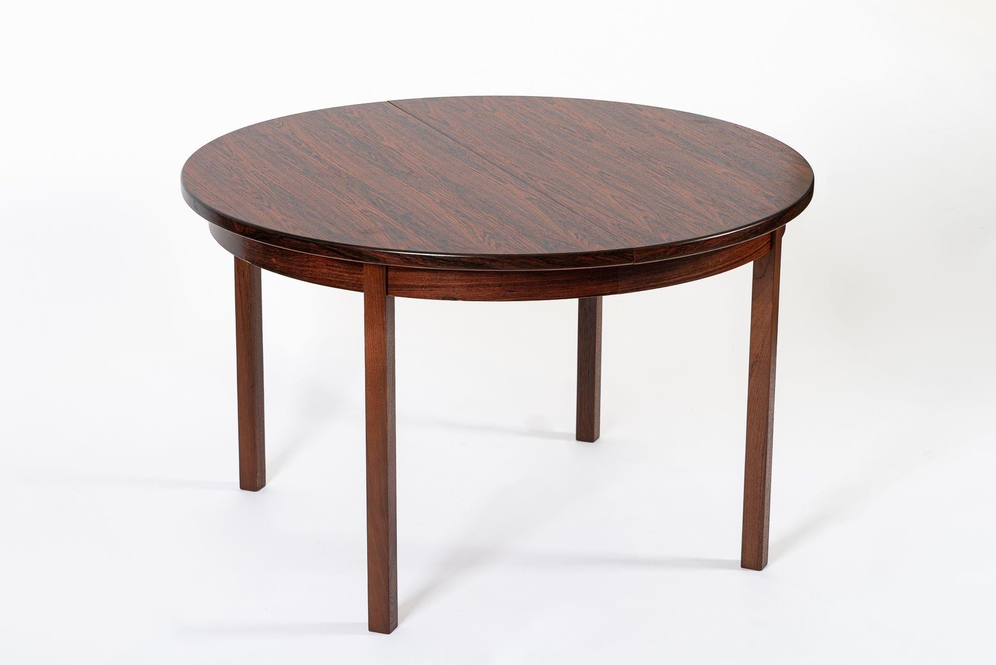 This vintage mid century Swedish modern extendable rosewood dining table was designed by Nils Jonsson for Troeds and made in Sweden circa 1960. This beautiful table has clean, minimalist lines and is incredibly well constructed from solid wood and