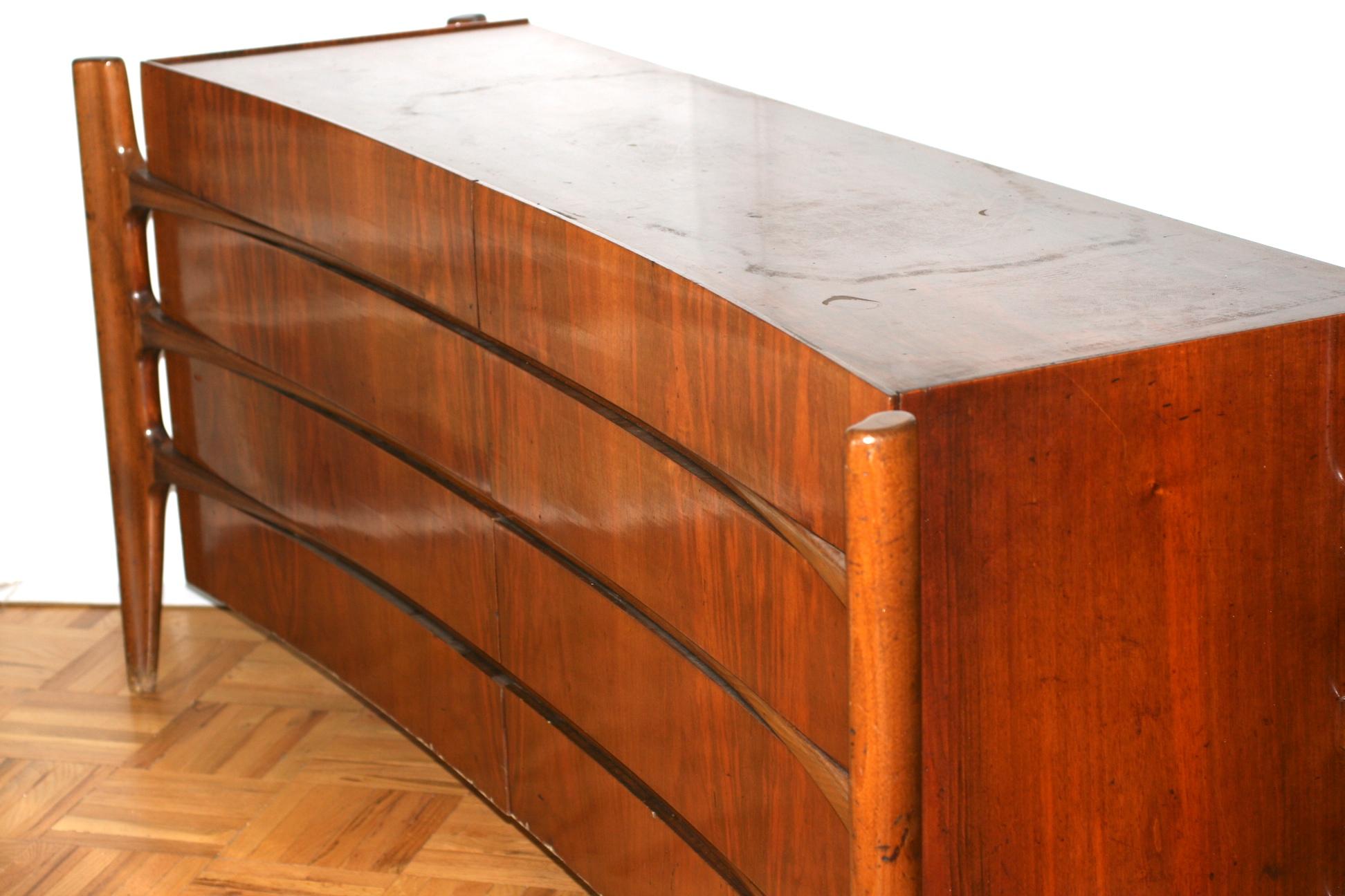 Wonderful curved and sculptural dresser or credenza from the 1950s Sweden with an exposed biomorphic frame of exquisitely hand-sculpted solid walnut intersects which appear as spider like legs suspending an eight-drawer dresser cabinet with a curved