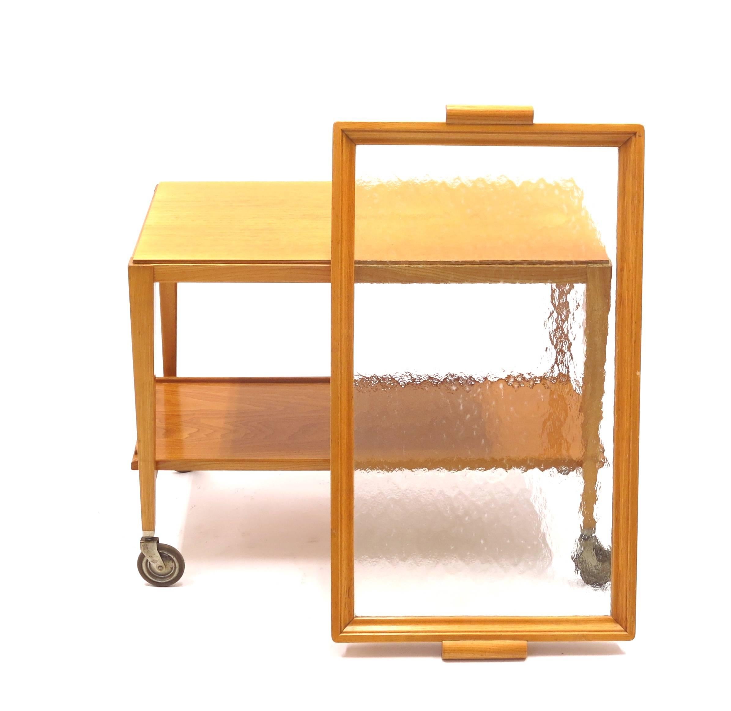 This Swedish bar or serving trolley is made from blonde wood with a dismountable glass tray. It was manufactured by Bodafors in the 1950s. Very good original vintage condition.