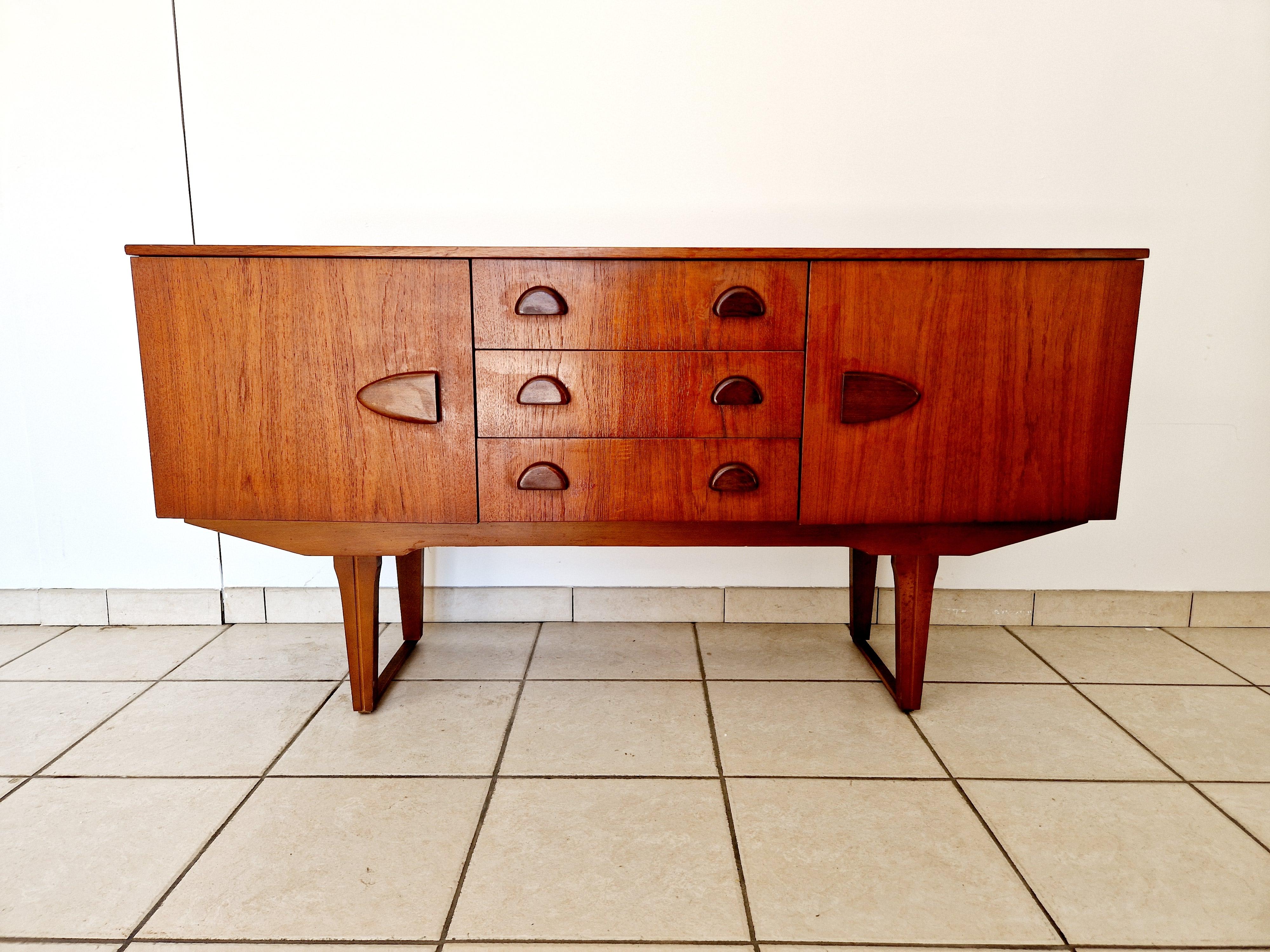Realizzata con un occhio al design classico, questa credenza in teak del Mid Century offre un mix di funzionalità e stile senza tempo. Il pezzo presenta una ricca struttura in teak, completata da una finitura laminata che ne esalta l'estetica retrò.