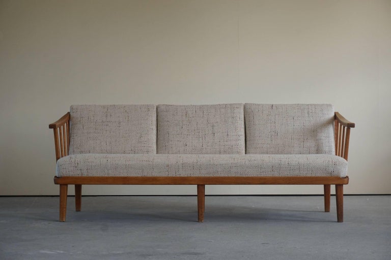 Stunning three seater sofa by Carl Malmsten for O.H Sjögren. 1960s. Model Visingsö in solid oak and reupholstered in thick 100% wool. Removable cushions, so that you can adjust the look.

The designer Carl Malmsten, one of the giants of Swedish
