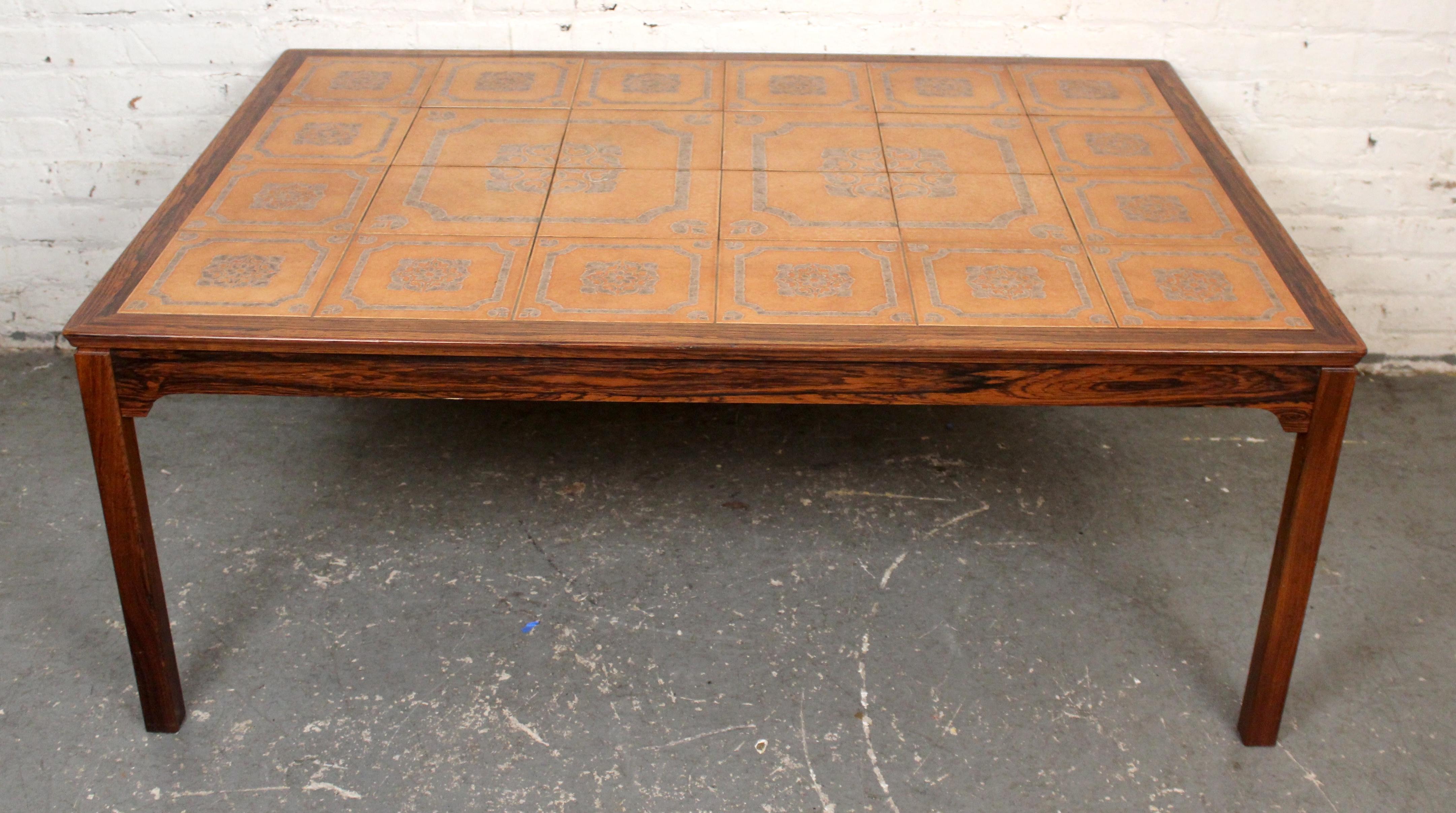 Attractive and versatile mid-century vintage coffee table in the manner of Danish artist Tue Poulsen manufactured by Swedish maker String-Seffle Möbelfabrik. A rich rosewood veneered frame features architectural lines with an eye-catching and