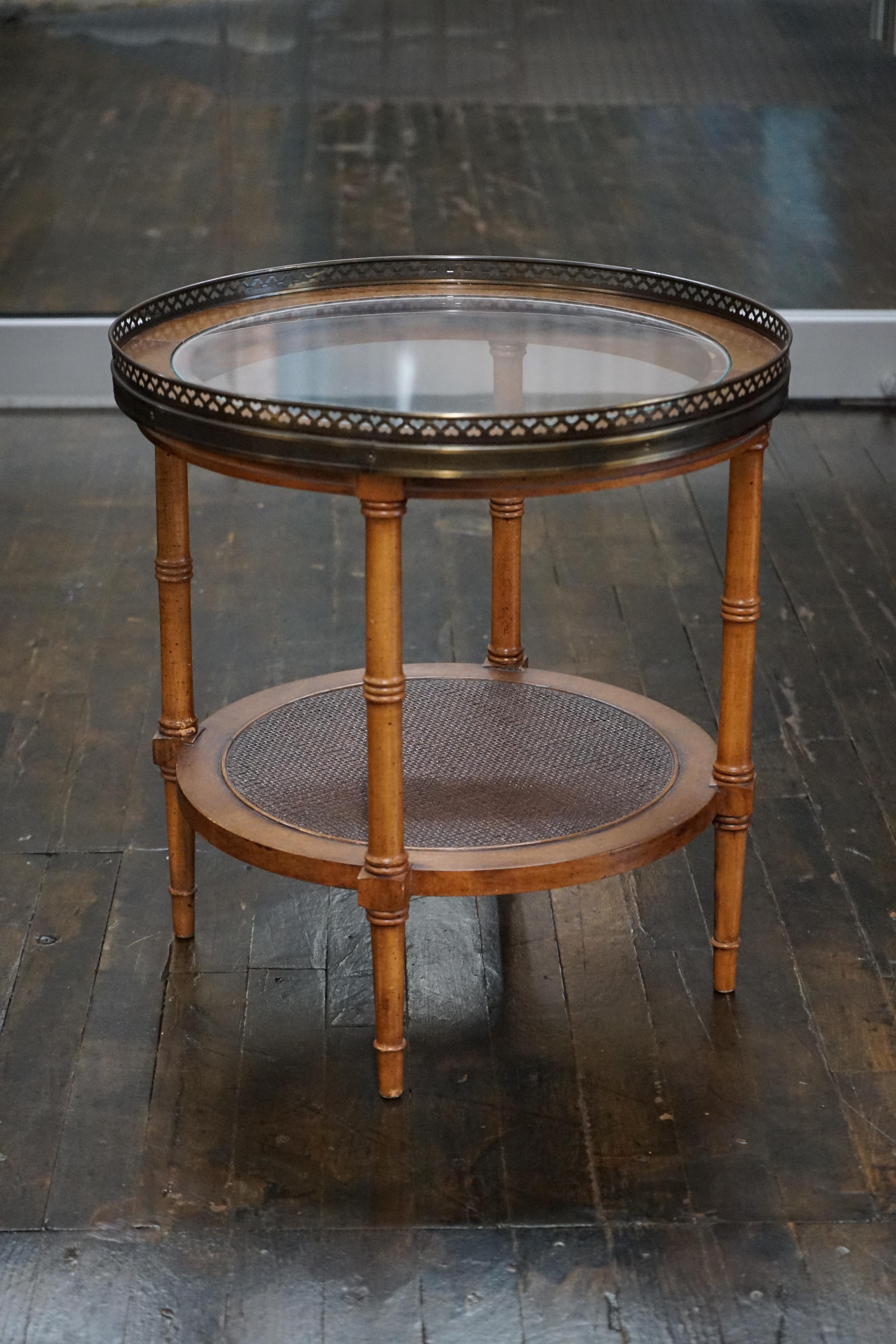 Table d'appoint du milieu du siècle dernier avec des pieds en faux bambou, un insert en verre sur le dessus, une jolie garniture métallique percée (avec des découpes de cœurs) et une étagère inférieure en canne.