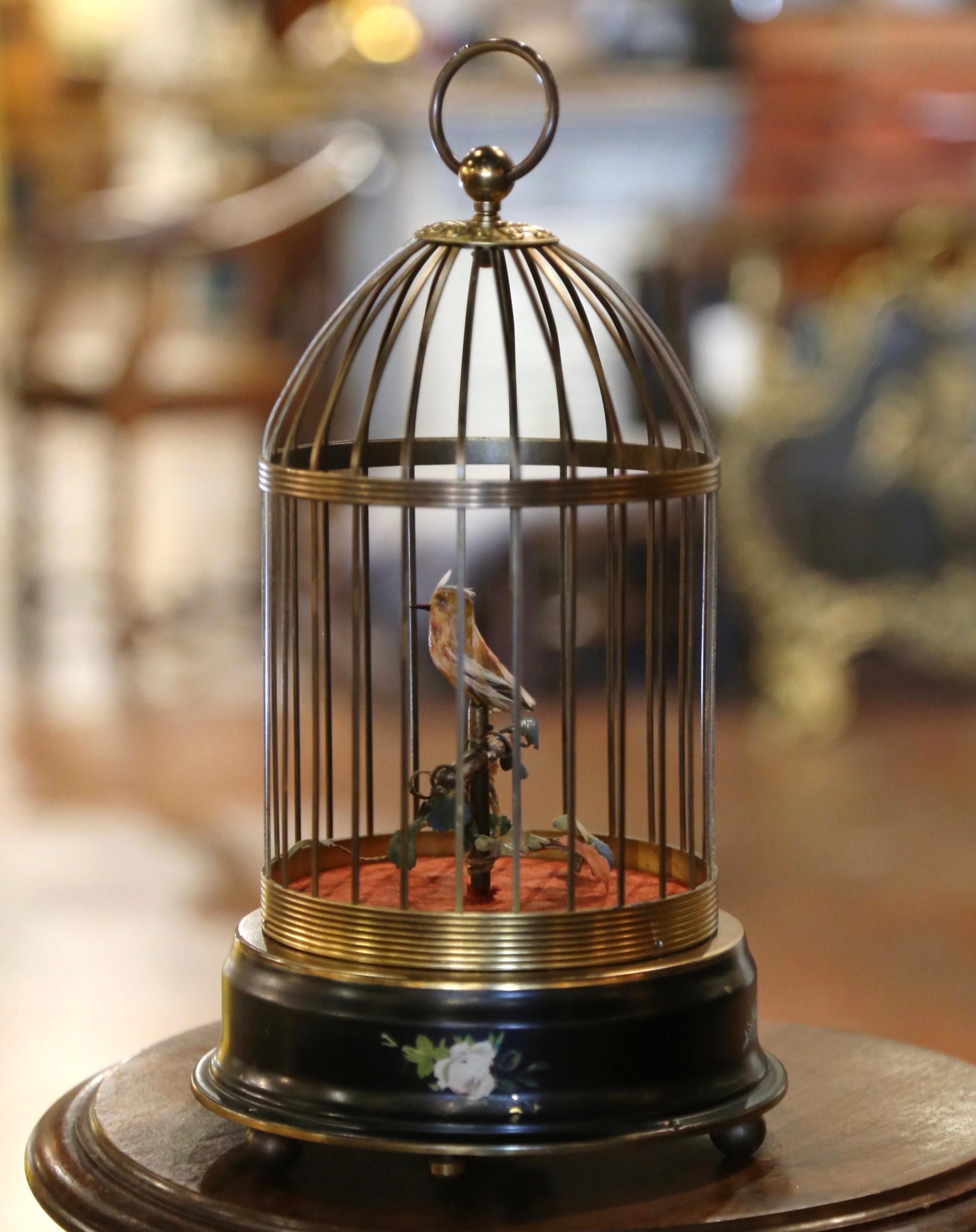 Bring life to your house with this colorful vintage birdcage. Attributed to Reuge Music in Switzerland, and built circa 1960, the cage is cylindrical in shape and sits on a painted wooden base decorated with hand painted floral and leaf motifs; the