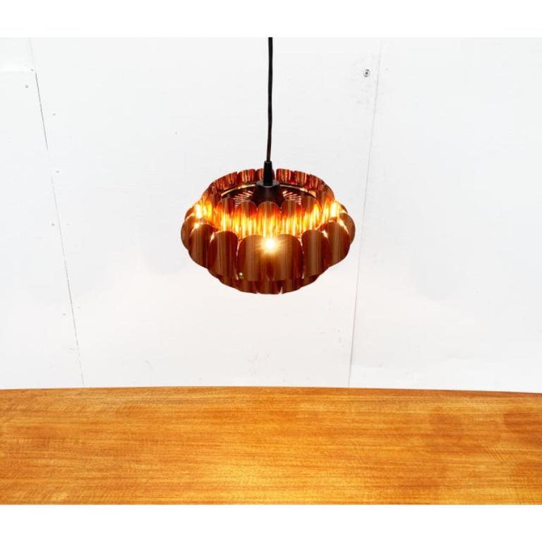 Imponente lampada a sospensione di Temde basata su un design di Thorsten Orrling degli anni '60.

Un design elegante e senza tempo con un'imponente superficie in rame. Il design si basa sull'aggiunta di un elemento di base, disposto radialmente e in