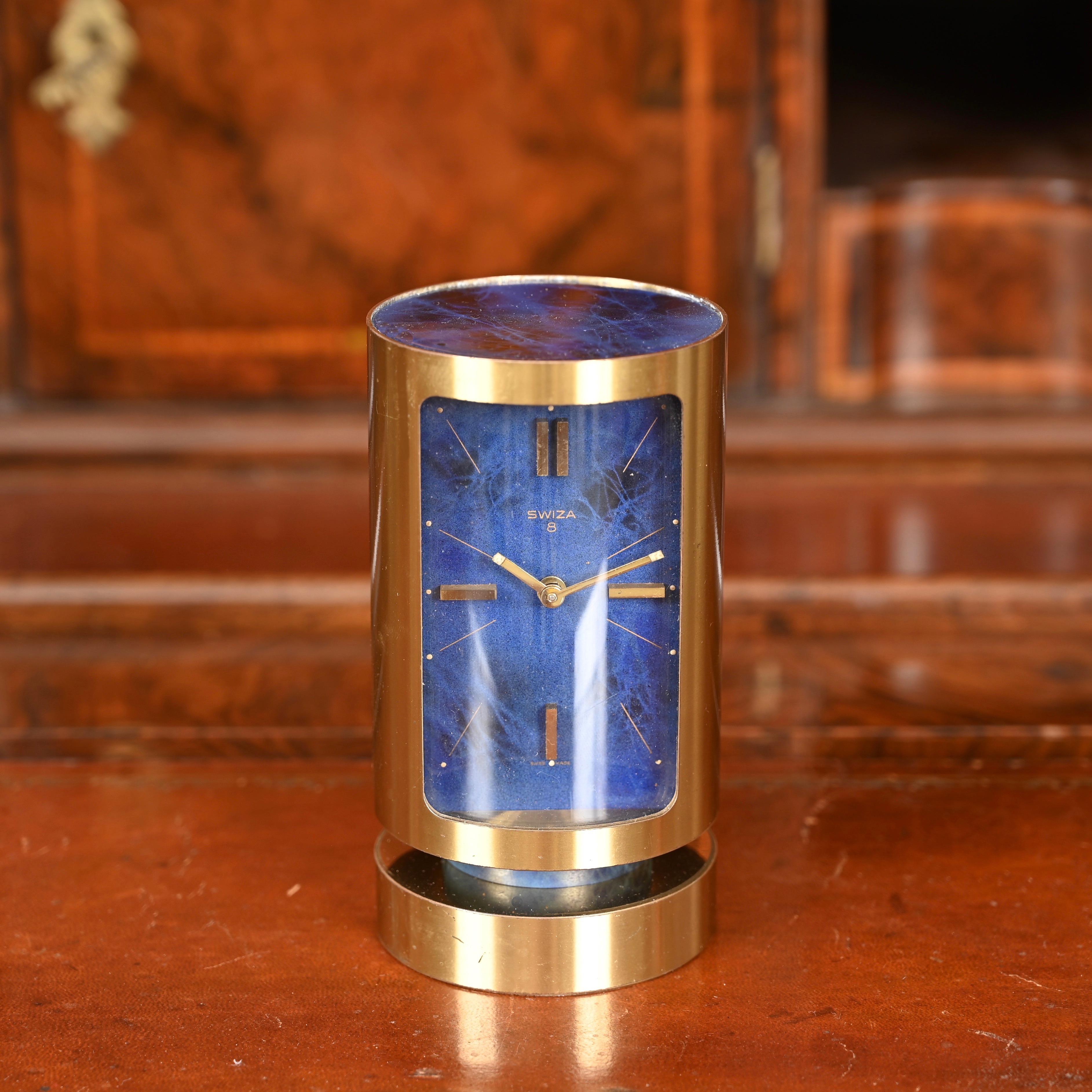 Fabulous Mid-Century Swiza with 8-day movement and original 1960s alarm clock in a stunning combination of gilt brass and real lapis lazuli. This amazing piece was designed in Switzerland in the 1960's.

This charming heavy gilt cylinder shaped