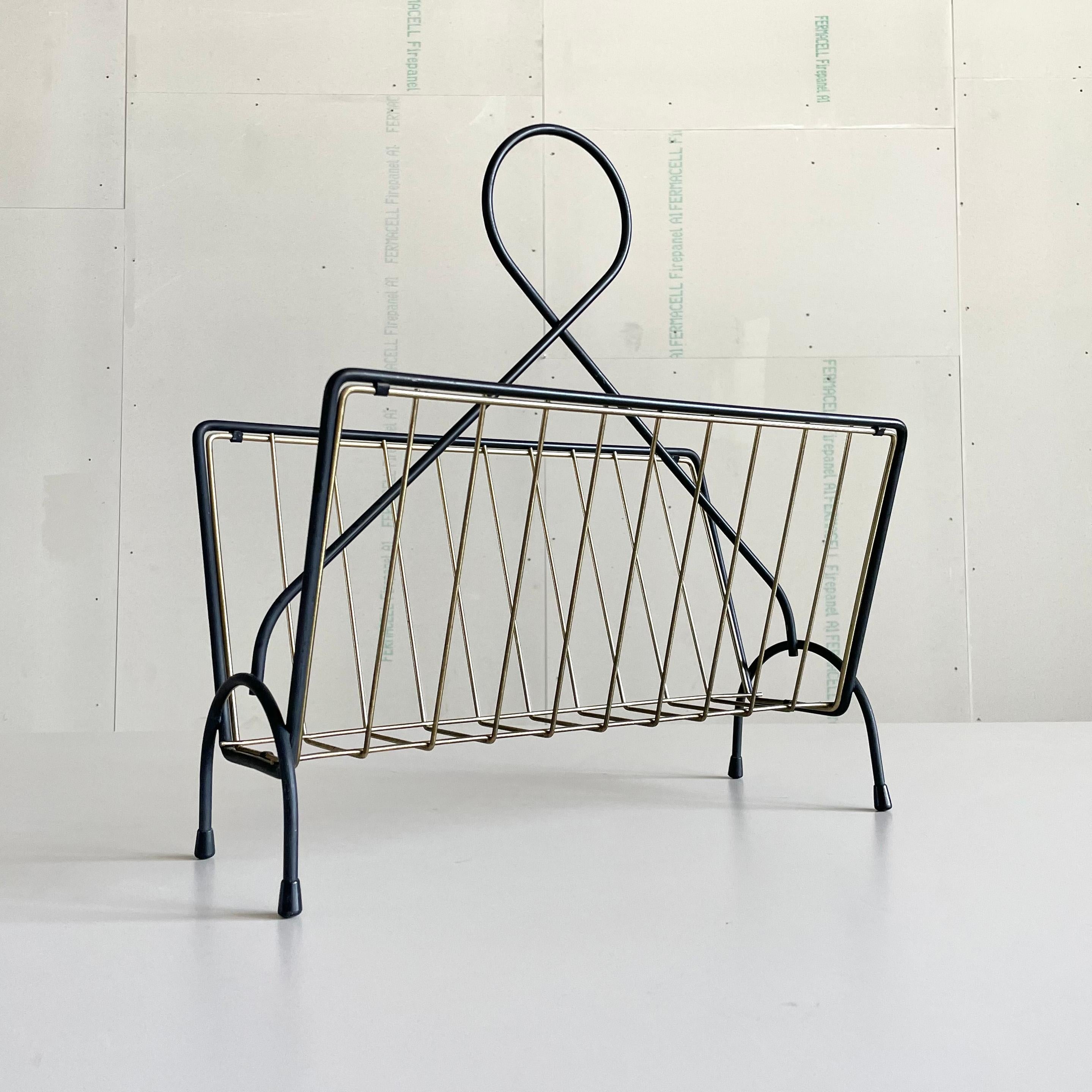 Stylish Mid Century Swiss made Magazine / Newspaper Rack with Brass details and rubber feet. Believed to be produced for Möbel Pfister, Switzerland in the late 1950’s, early 1960's 
Measurements: Height: 47.5 cm  Width: 42 cm  Depth: 18.5 cm