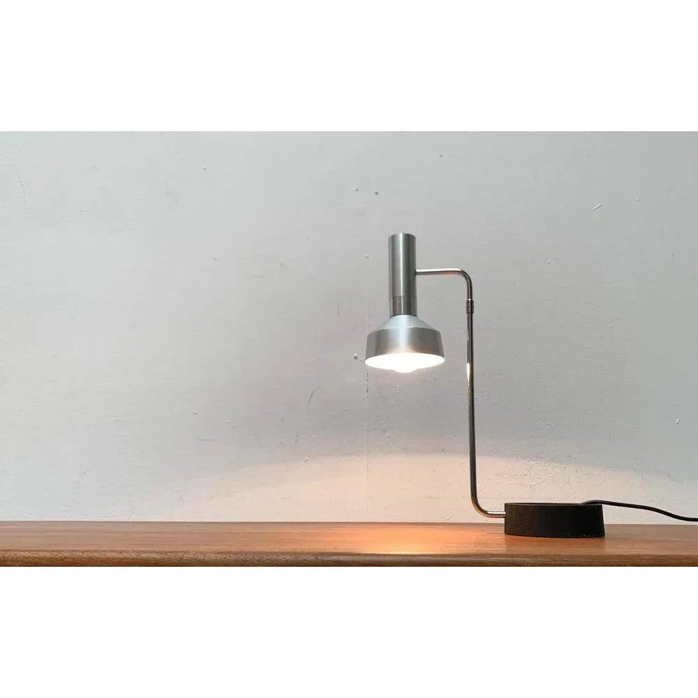Minimalist table lamp from the Swiss manufacturer Baltensweiler according to a draft by Rosemarie and Rico Baltensweiler from the 1960s.

A functional design in a very factual design language. The light head consists of a simple aluminum cylinder