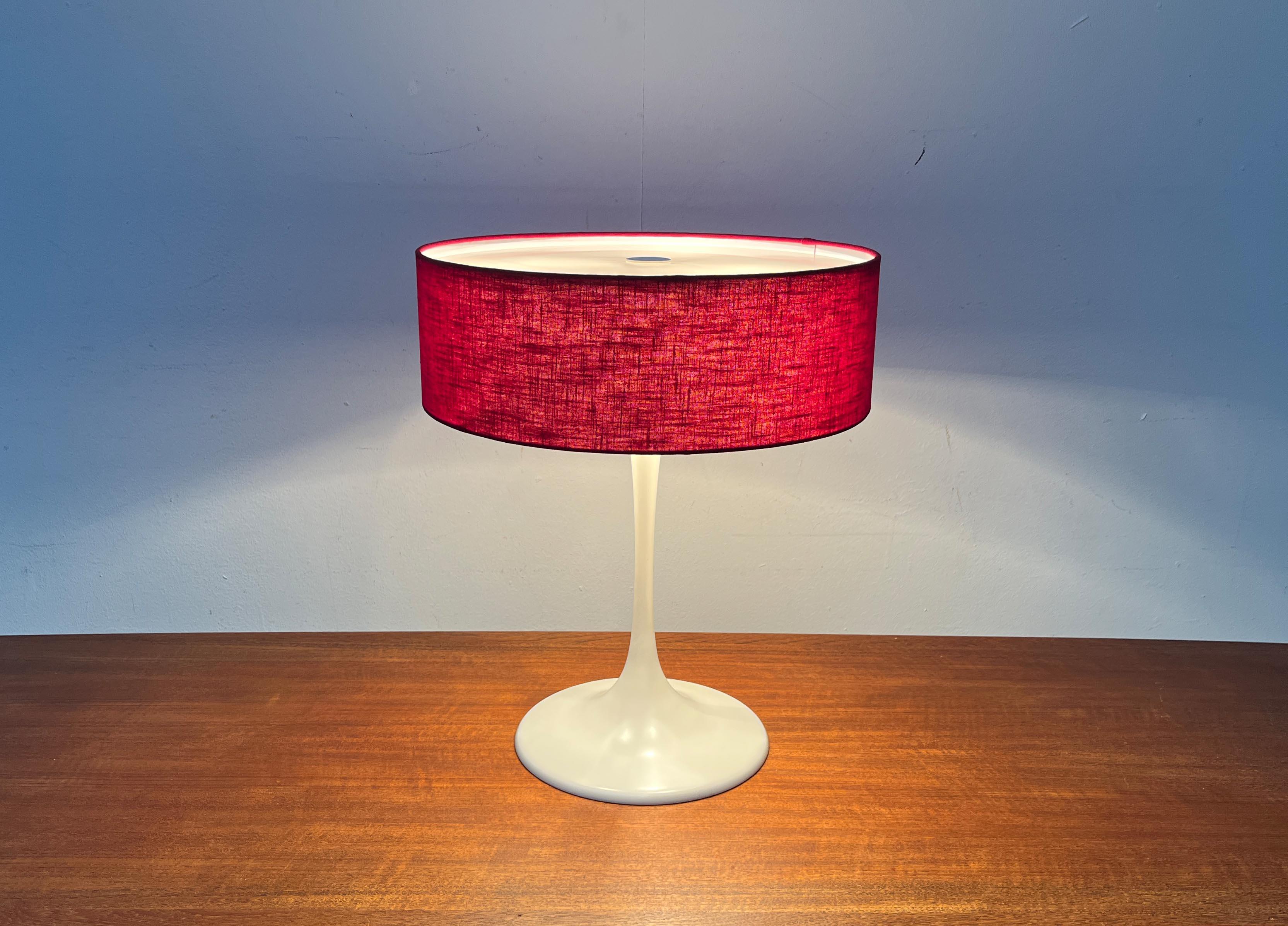 Rara lampada da tavolo del produttore svizzero Temde.

Una fonte di luce funzionale e un oggetto luminoso di grande effetto. La tonalità stretta con la copertura rossa dalla struttura grossolana è sorprendente. Il fusto sottile è elegantemente