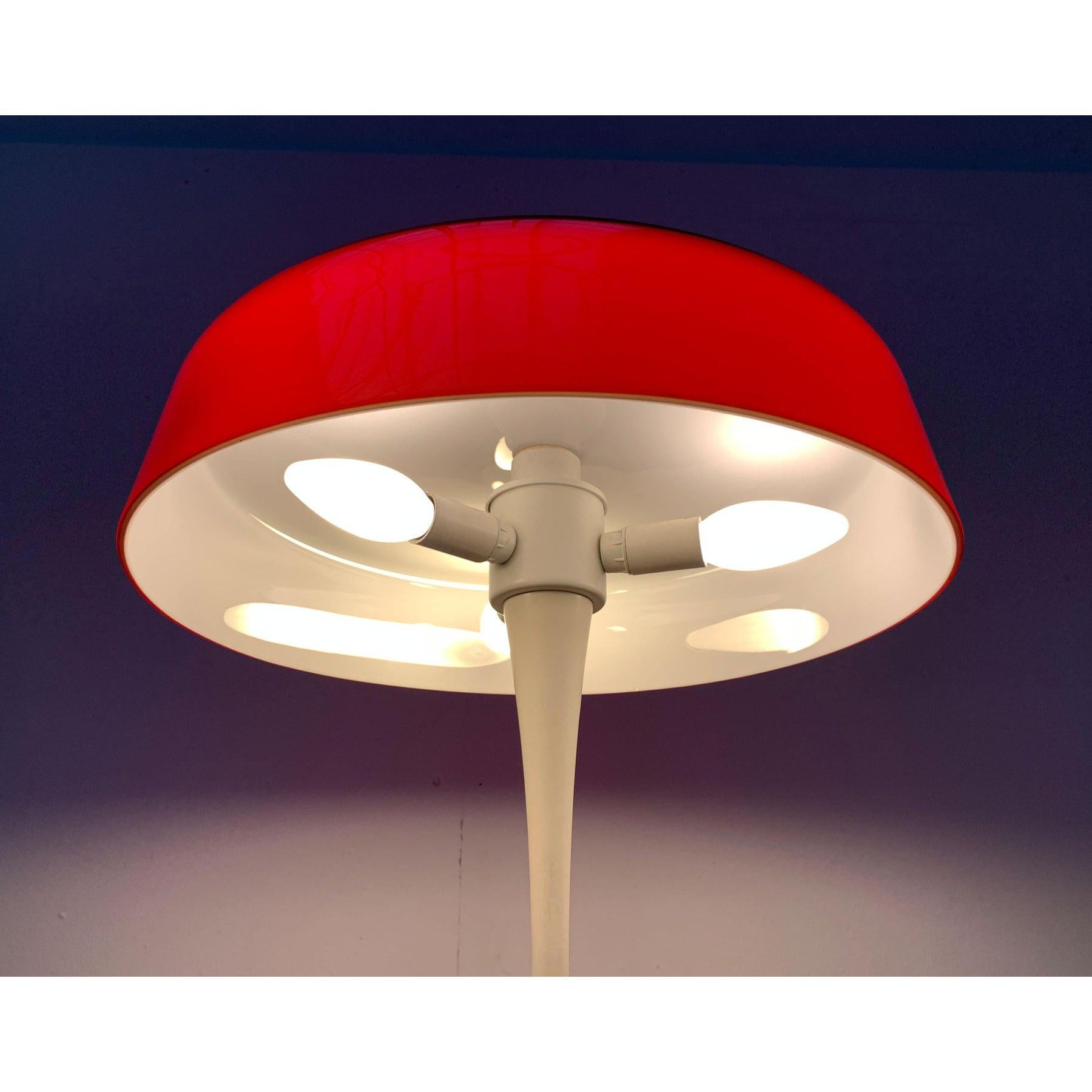 Rare table lamp from the Swiss manufacturer Temde.

A functional light source and at the same time impressive light object in the room. The most striking detail is the large diffuser shade made of red overhauled glass. The slim shaft is elegantly