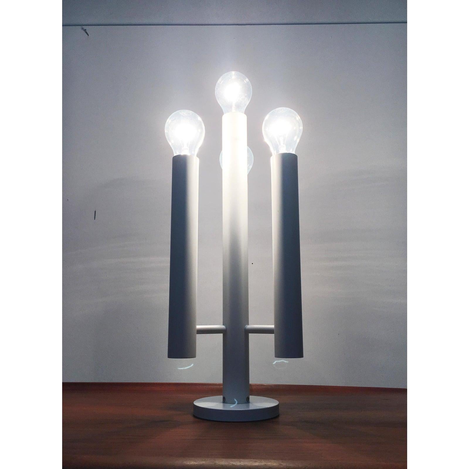 This is a rare table lamp from the Swiss manufacturer Temde.
It is both a functional light source and a very decorative object. The design is reminiscent of a candlestick. The lamp consists of a central, long cylinder, from which 3 further cylinders