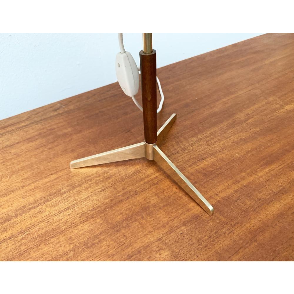 Rara lampada da tavolo di metà secolo con piede a tre gambe del produttore svizzero Sub.

Il design colpisce per la sua forma elegante e l'alta qualità dei materiali. L'ombrello a forma di tamburo è ricoperto da un tessuto rosso. Sulla parte