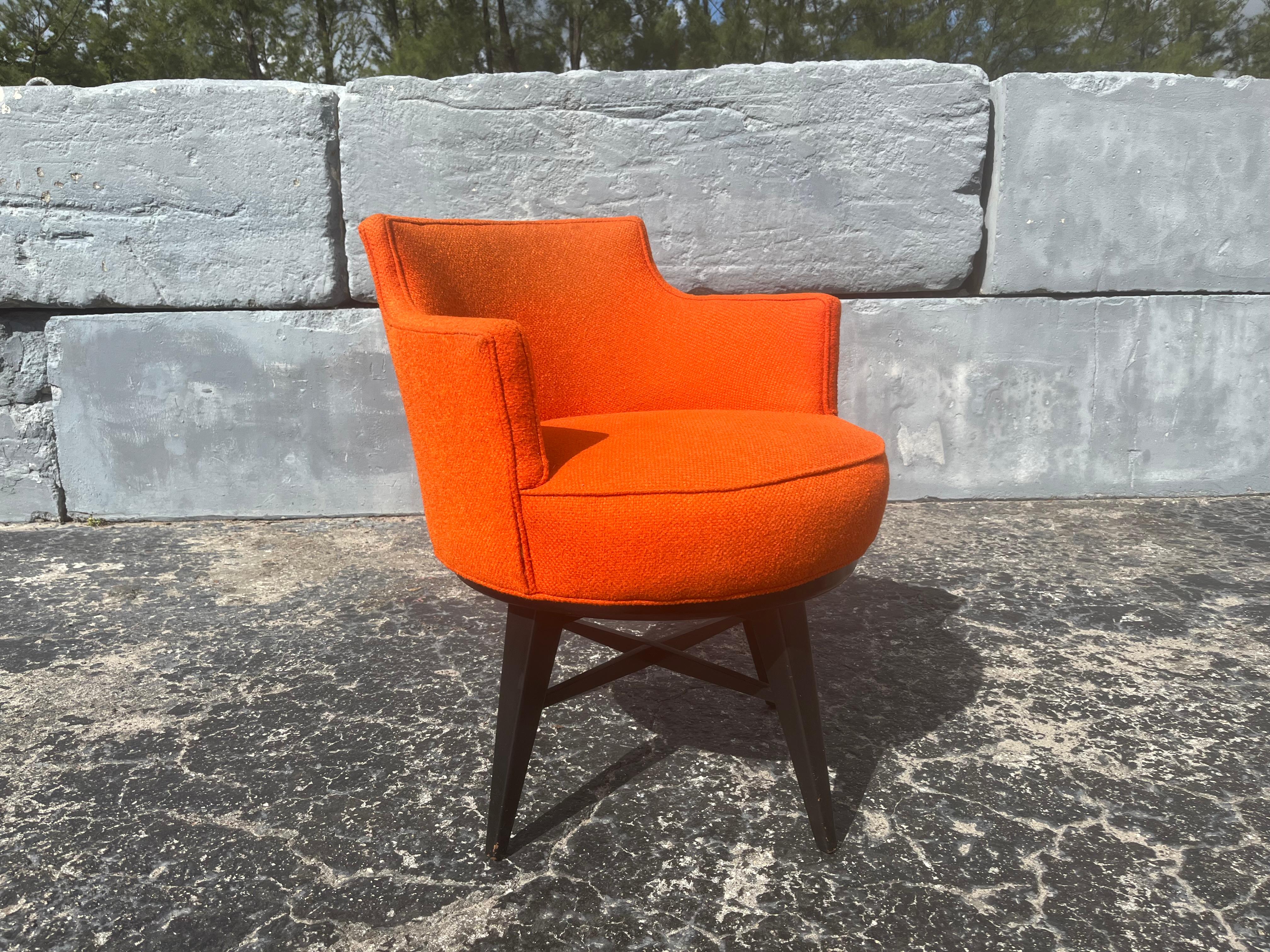 Original 1950s Swivel Arm Chair, tissu orange et base en bois peint en noir. La hauteur des bras est de 26.50