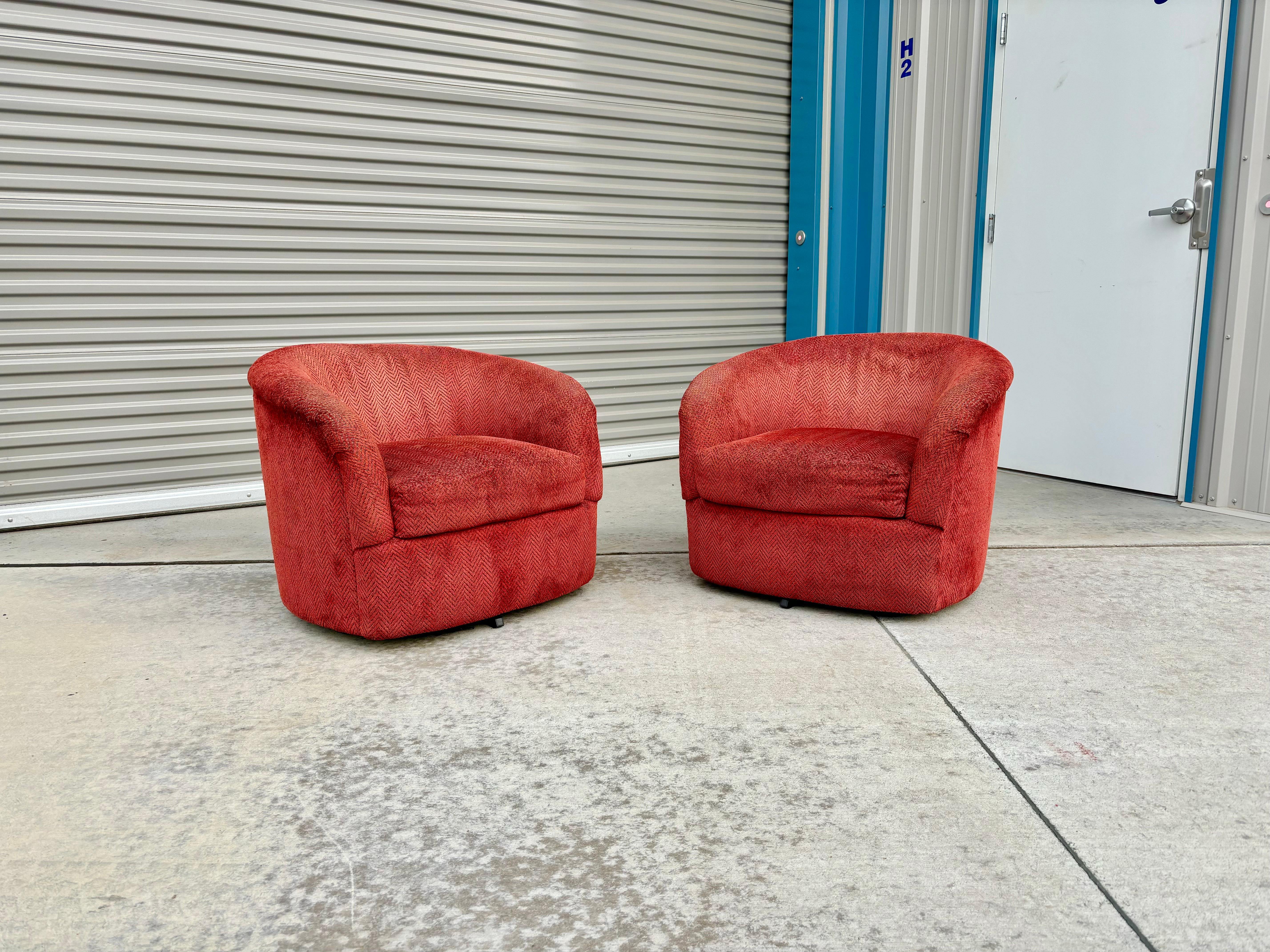 Mid-century swivel barrel chairs designed and manufactured in the United States circa 1960s. These beautiful lounge chairs have a red upholstery swivel base that rotates 360 degrees. These swivel chairs are guaranteed to draw attention, the perfect