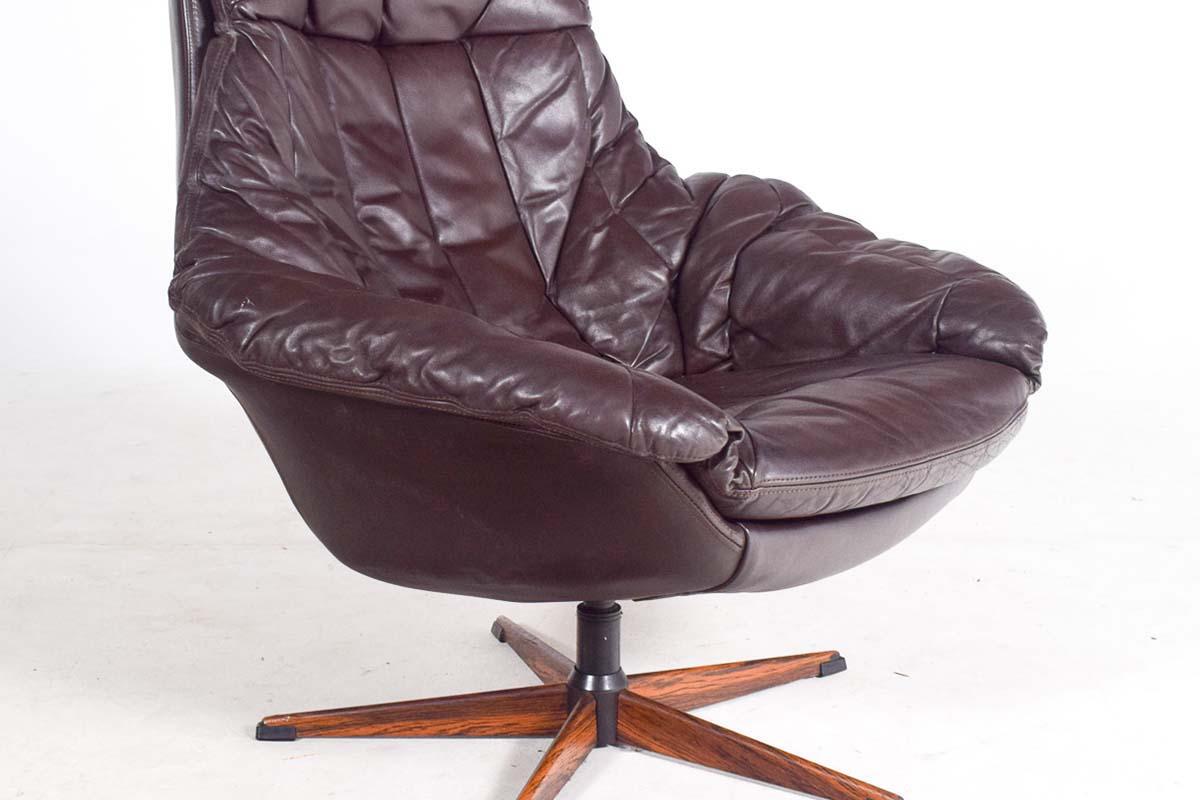 This swivel chair, designed by Danish designer Henry Walter Klein in the 1960s for Bramin Møbler, exemplifies mid-century modern elegance and comfort. Manufactured around 1975, the chair is upholstered in original soft brown leather, offering a