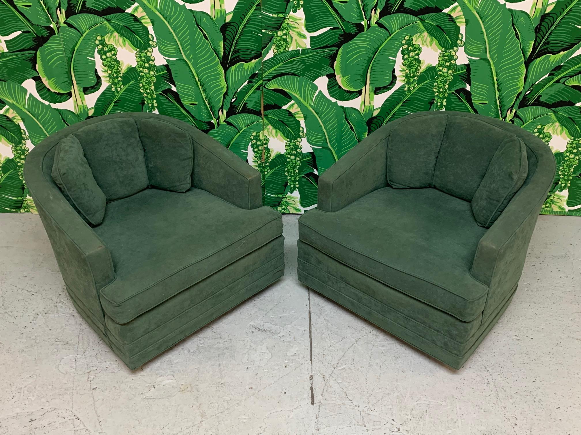 Pair of midcentury swivel chairs by Kaylyn feature dark green faux suede upholstery and low slung design. Good vintage condition with imperfections consistent with age. No holes, tears, or odors.