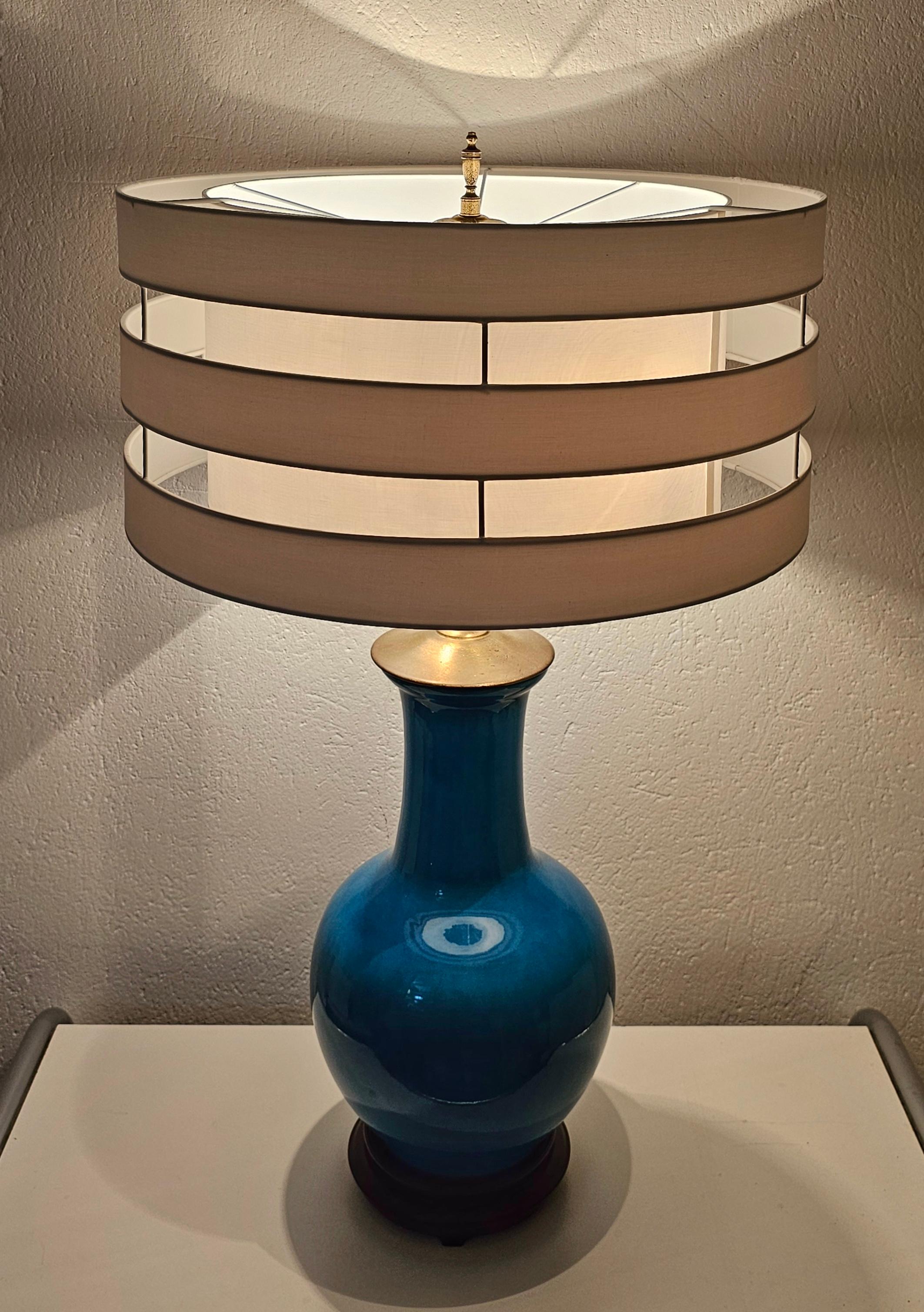 In this listing you will find a rare and large Mid Century Modern table lamp by Warren Kessler New York. The lamp is made in blue ceramics, with mahogany base. It features 2 light bulbs and a large white shade, which is new. Made in the USA in