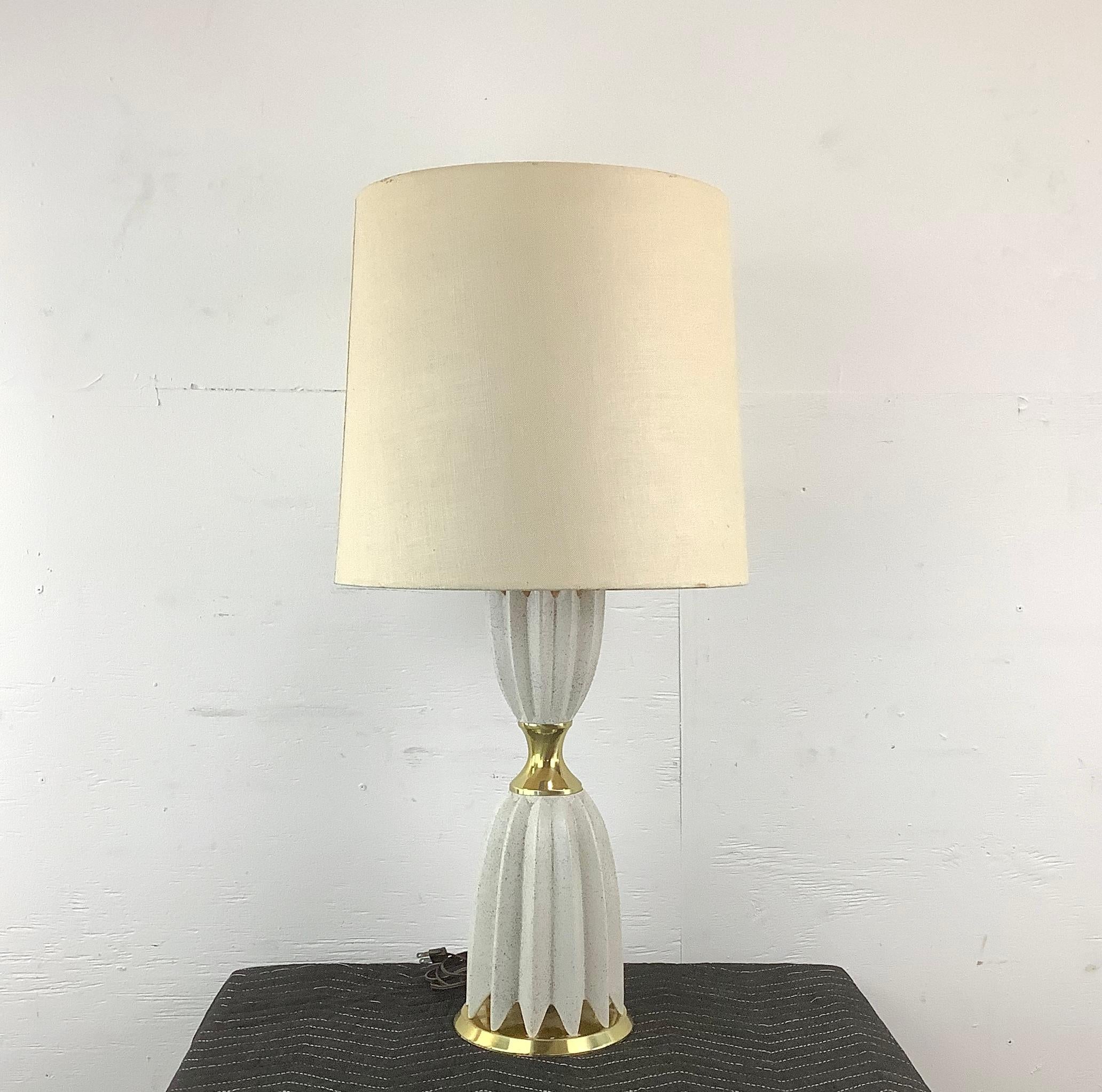Illuminate your home with the elegance of mid-century modern design with this ceramic and brass table lamp, attributed to the iconic Gerald Thurston as designed for Lightolier. This lamp, with its sleek ceramic body and warm brass accents,