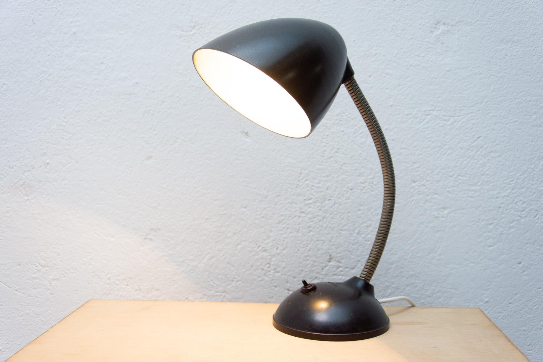 Le design de cette lampe de table en bakélite provient de Grande-Bretagne. Cette lampe à col de cygne a été conçue par Eric Kirkman Cole pour le marché de la République tchèque.
La production a ensuite été assurée par la société Elektrosvit sur le