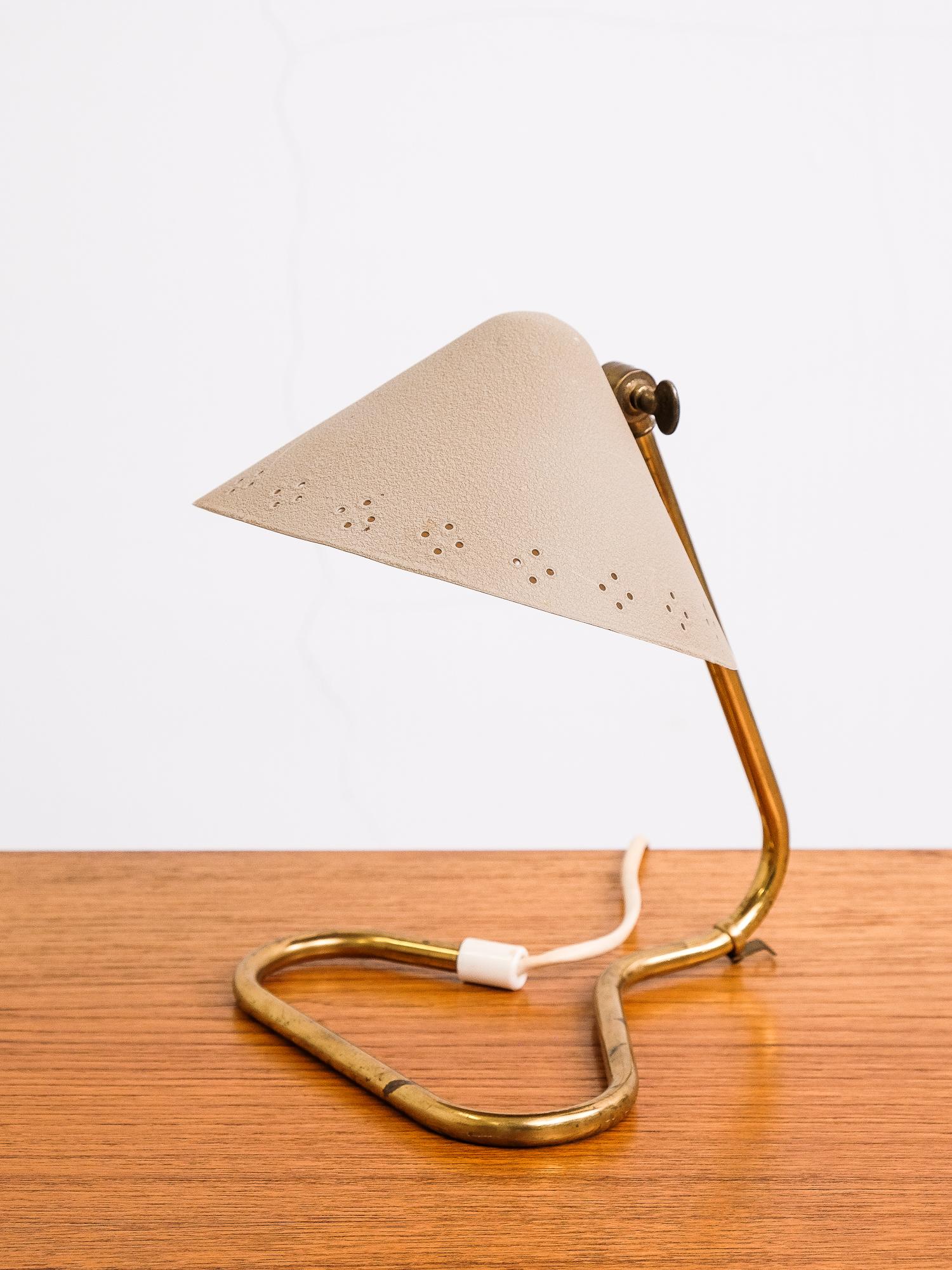 Rare and beautifully designed Swedish table lamp designed by Erik Wärnå and produced by Rydahls.

The lovely designed foot is made of brass and the shade is made of aluminum.
Lampshade can be pointed up or down, the holes in the shade have a nice