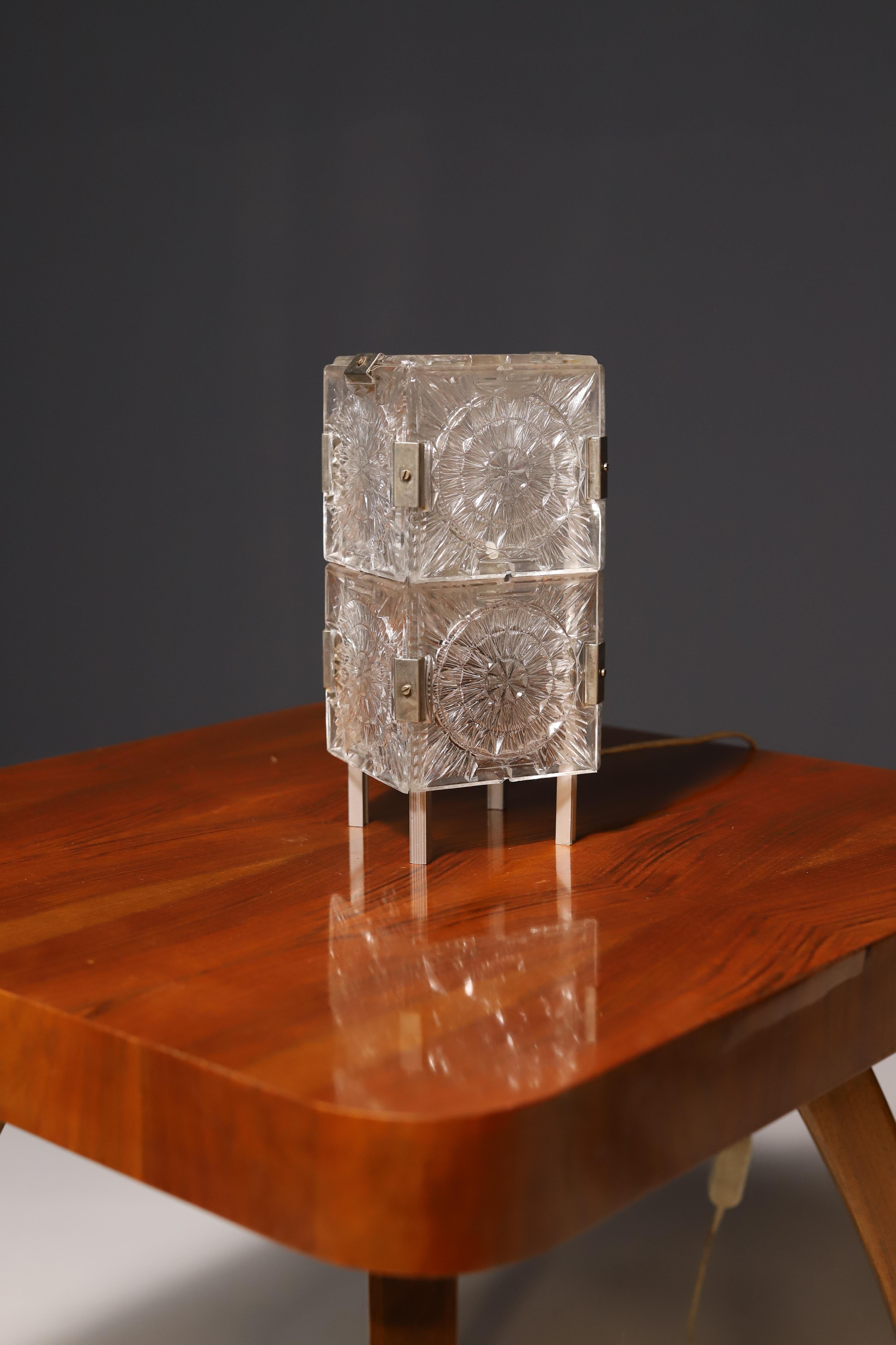 This mid century desk lamp was made by the Czechoslovak company Kamenický Šenov in the 1970s. It’s made of cut glass.
It’s in very good Vintage condition, fully functional.

Height is 28cm.
Width is 12 cm

Depth: 12 cm