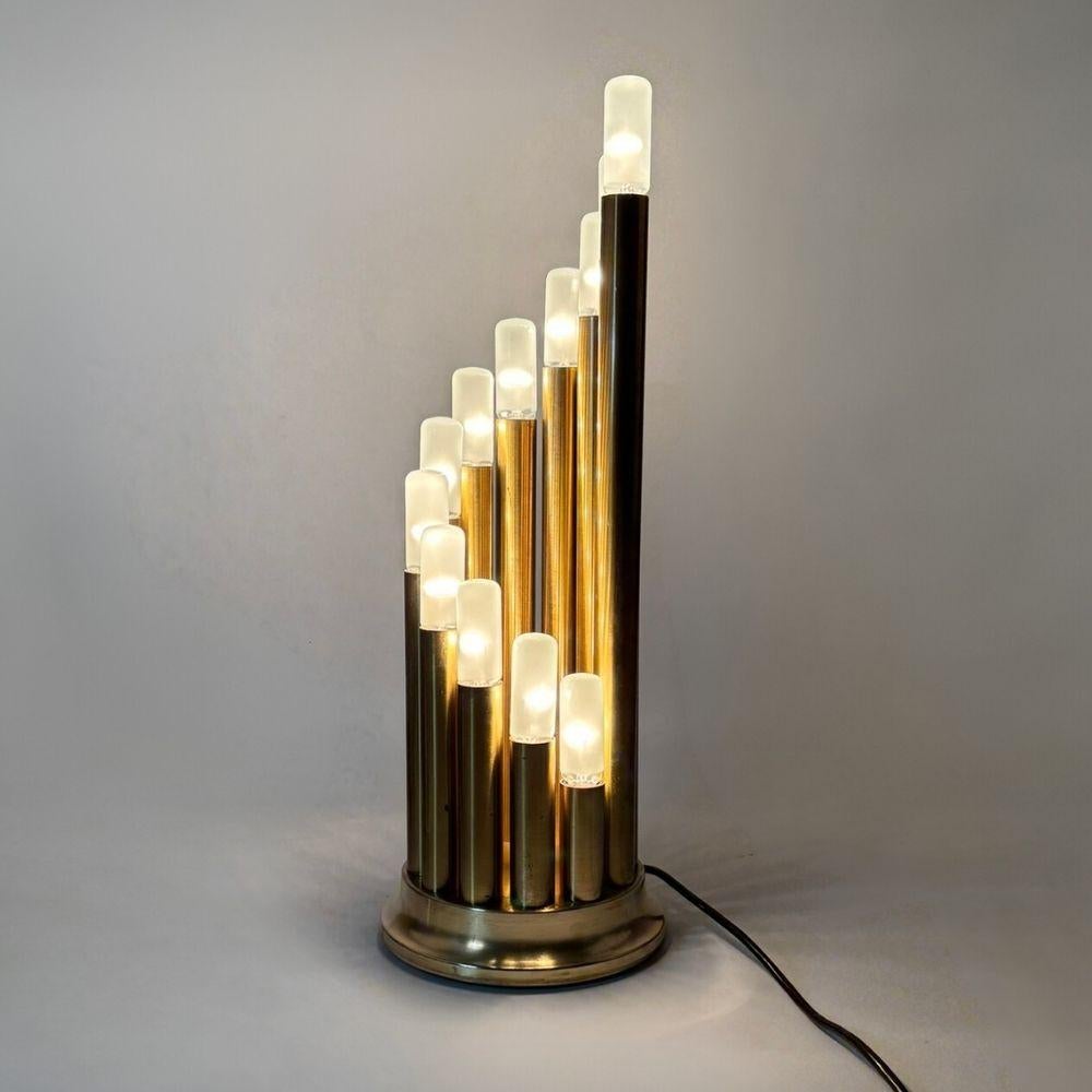 Rare lampe de table italienne Reggiani. Fabriqué vers 1970. Sa structure en forme de colonne se compose d'un groupe de 12 pièces de lampes en laiton. Les câbles d'origine sont inclus. Nous recommandons douze ampoules E14 10W maximum par luminaire,