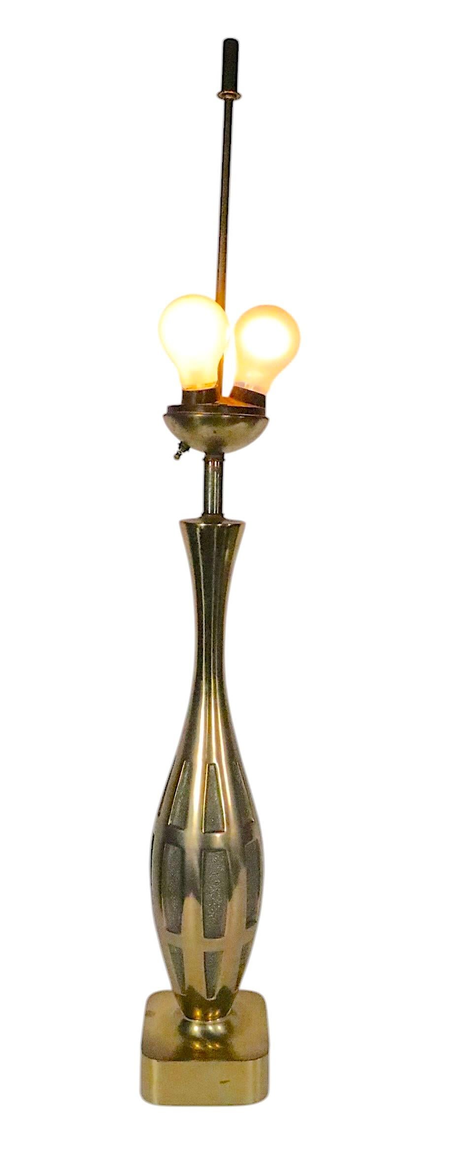Squisita lampada da tavolo in stile Hollywood Regency del Mid Century, disegnata da Tony Paul. La lampada è caratterizzata da una forma bulbosa a forma di birillo da bowling.  base in metallo color ottone con inserti in pannelli testurizzati. La