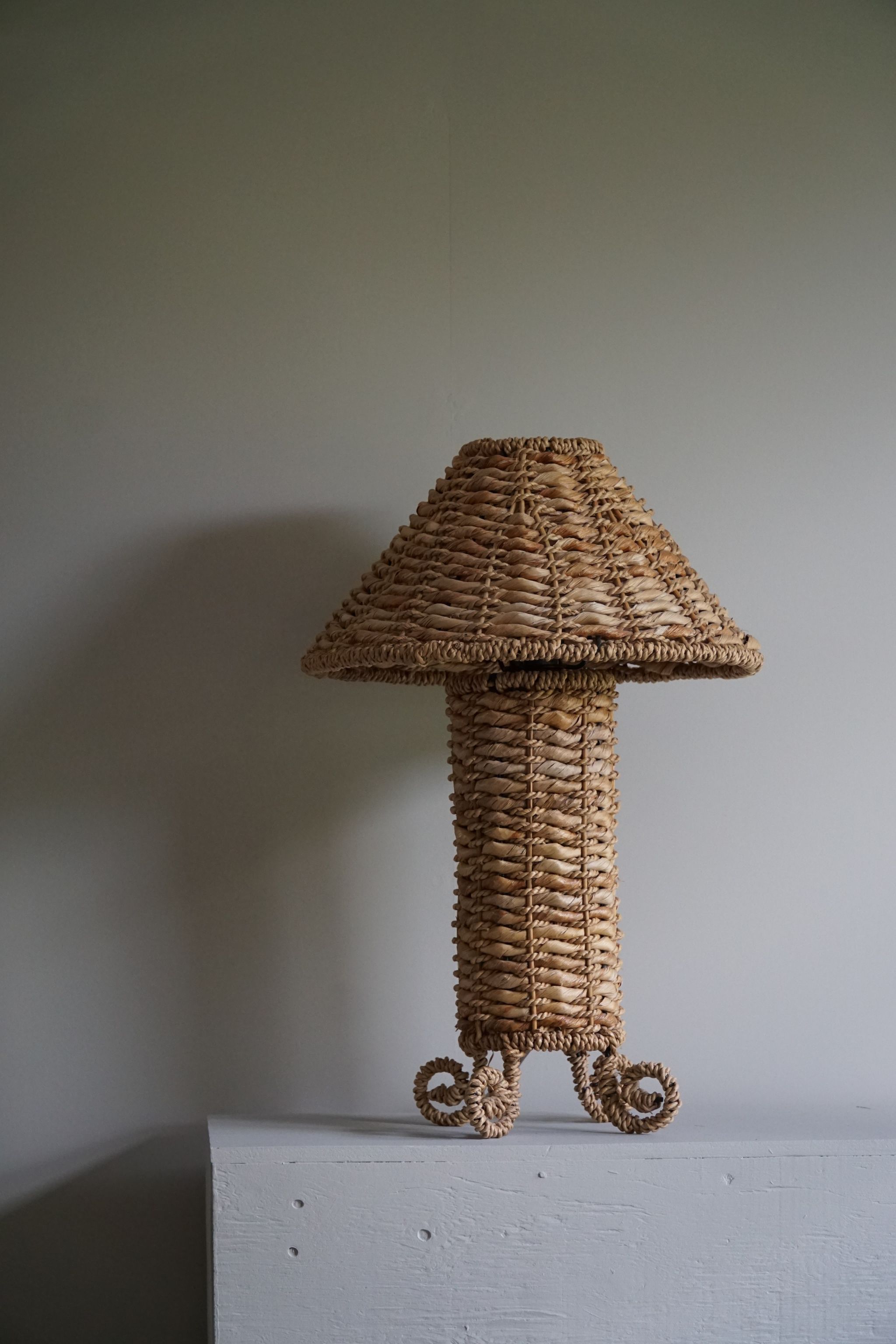 A decorative cute table lamp made in wicker and steel. A sculptural shape, made in Denmark ca. 1960-1970s.

The overall impression of this mid-century table lamp is really good.
It will complement many interior styles. A modern, classic,