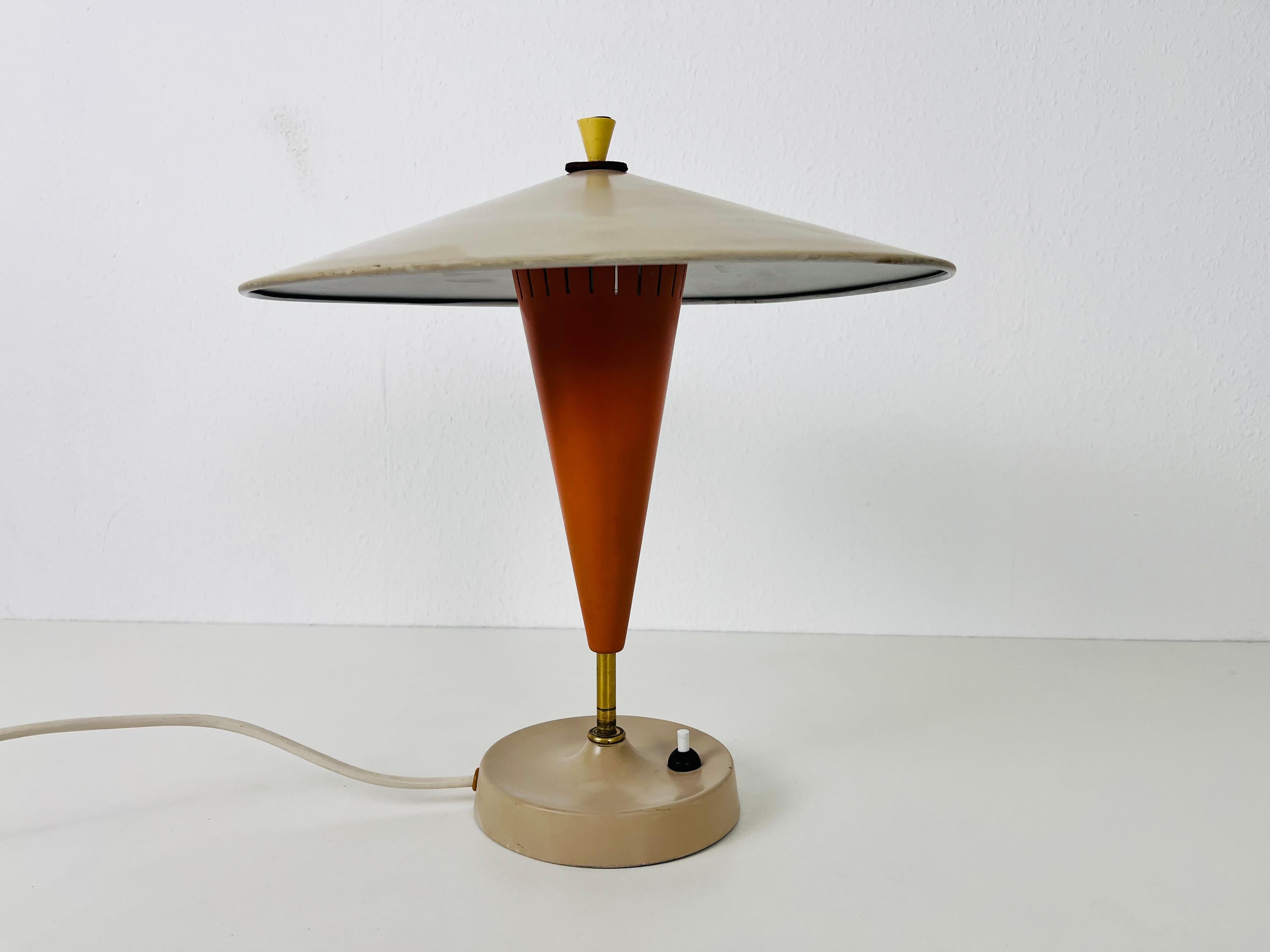 Una lampada da tavolo in metallo realizzata nella Germania dell'Est negli anni '60. La lampada ha un design eccezionale con una parte metallica regolabile all'interno, che cambia la luminosità.

La lampada richiede una lampadina E27 (US E26).